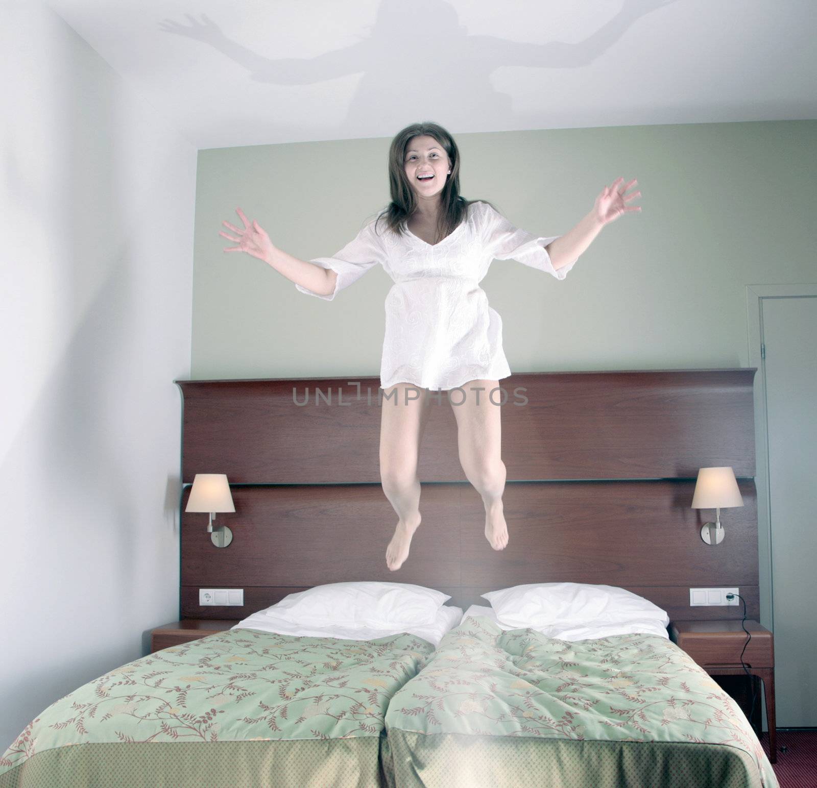 happy girl jumping in bed by craetive