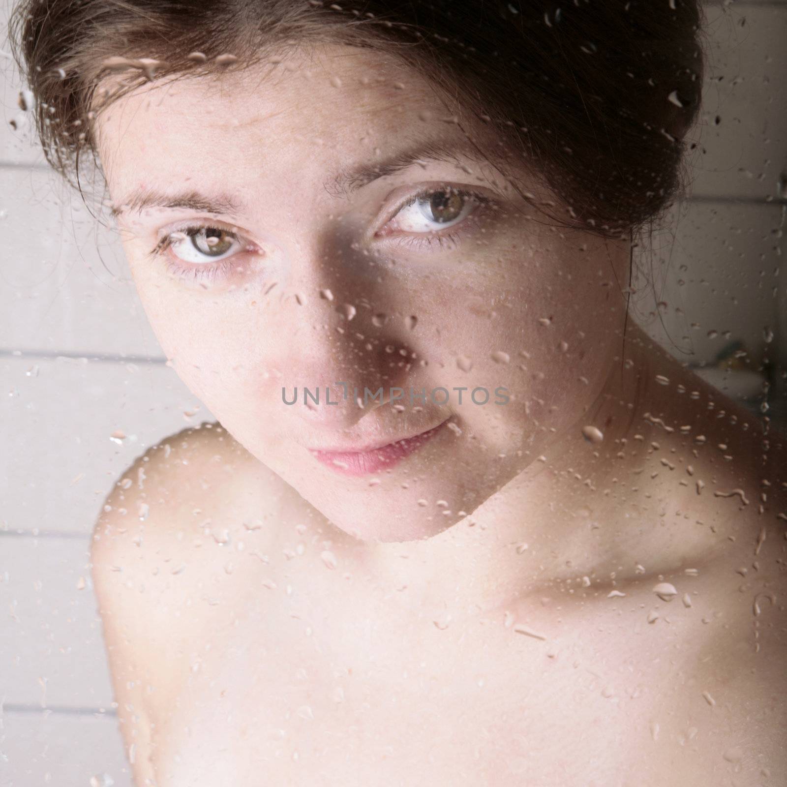 young woman looking through the shower cabin glass