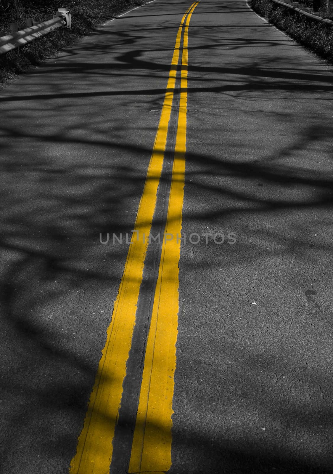 Abstract image of yellow lines on road with shadows
