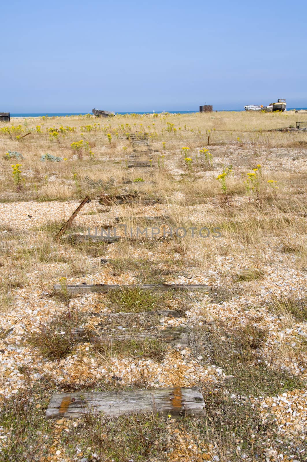 The beach at Dungeness with some huts in the distance