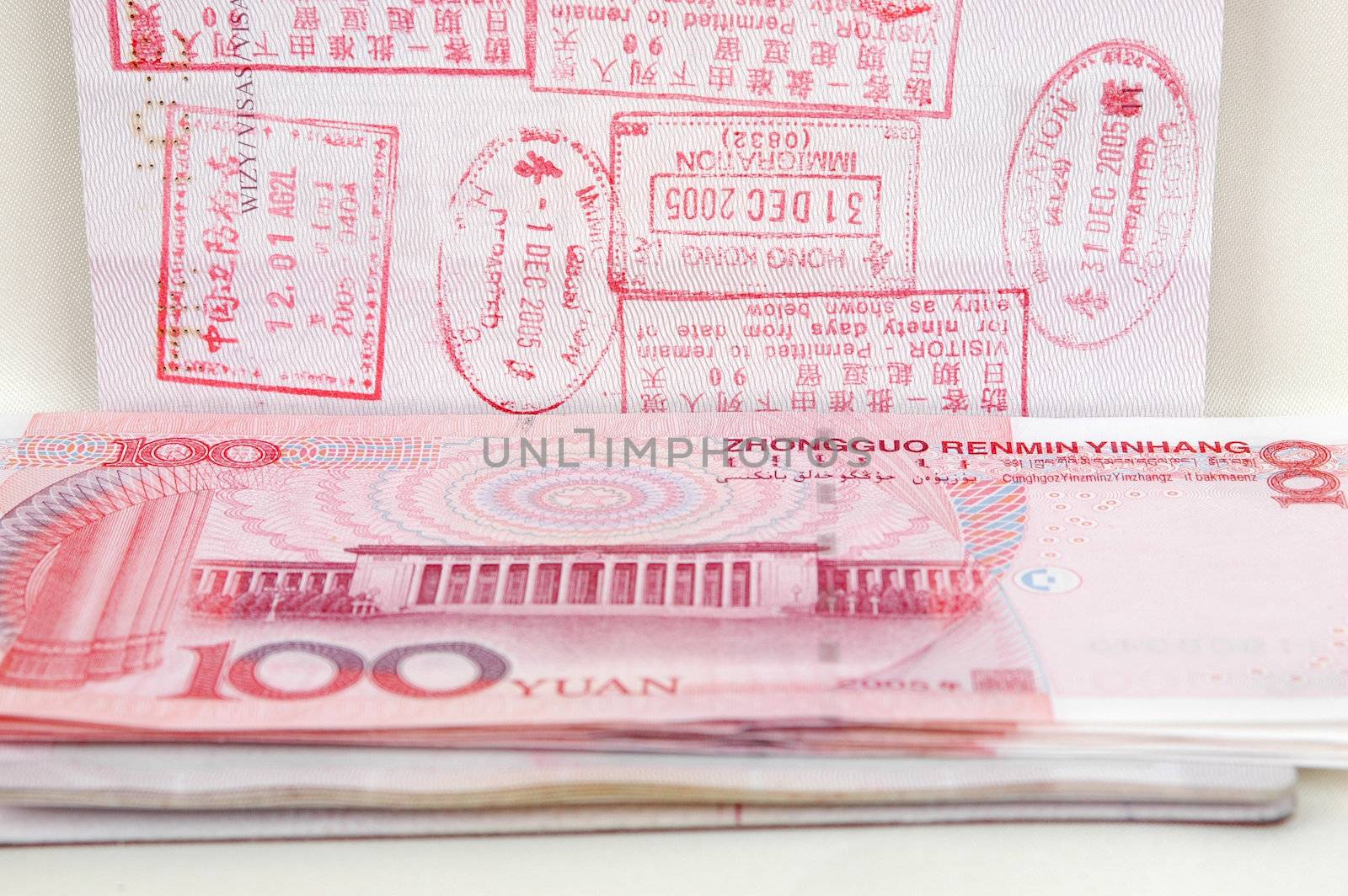 Passport full of stamps from China and Hongkong borders together with Chinese money, RMB banknotes.