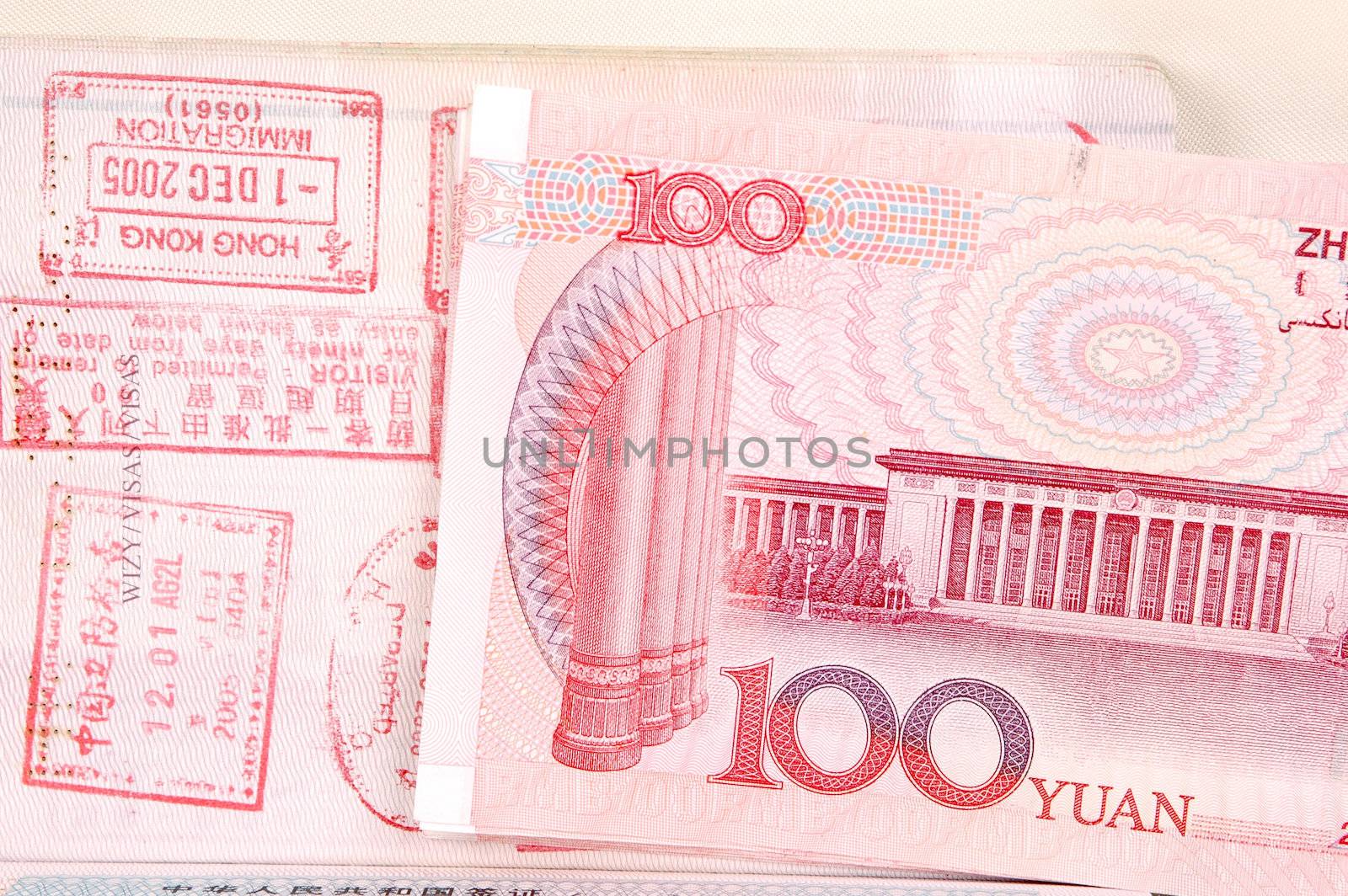 Passport full of stamps from China and Hongkong borders together with Chinese money, RMB banknotes.