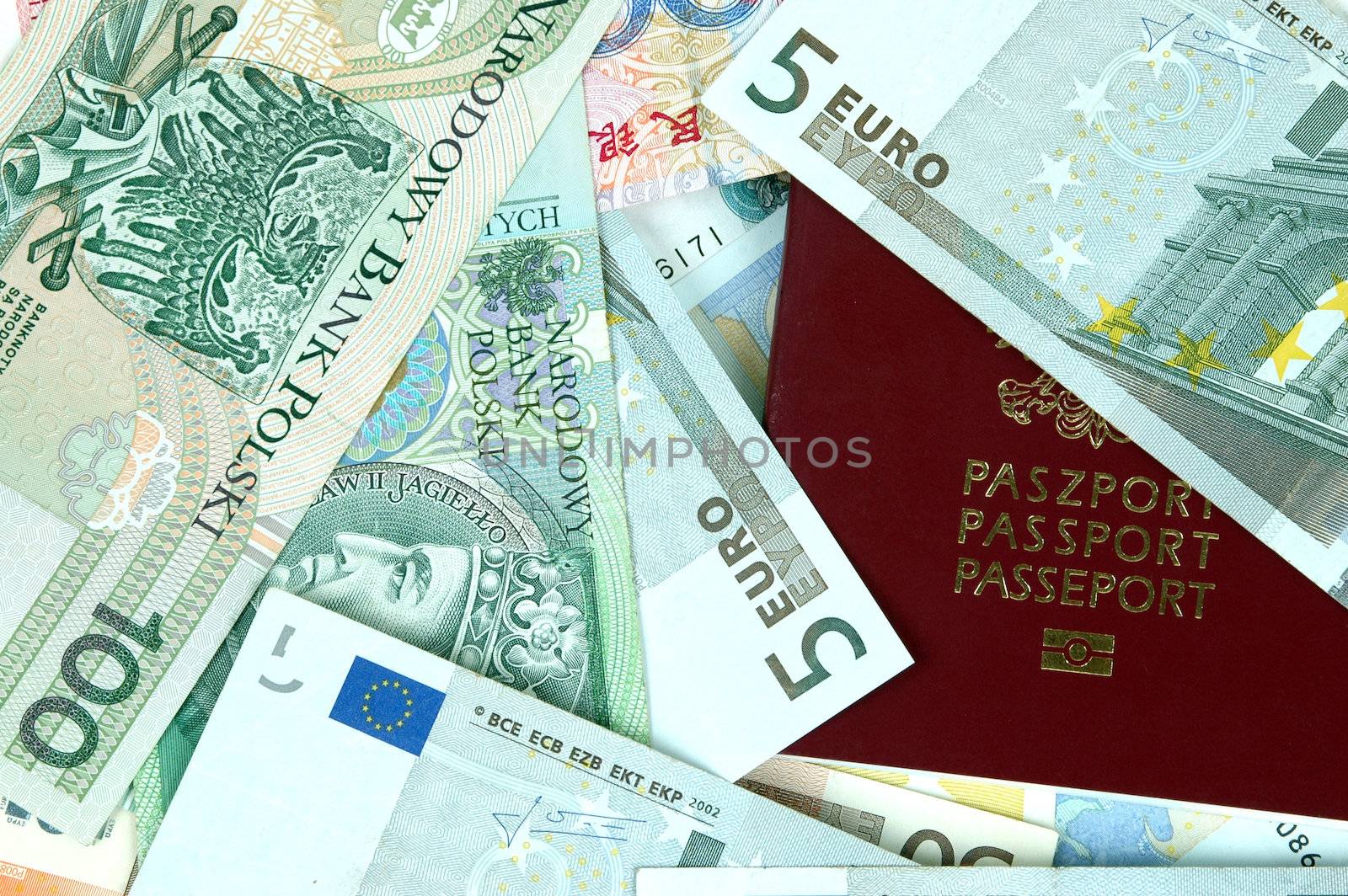 Closeup photo of European passport cover with different banknotes from Europe, China, Poland and Hongkong.