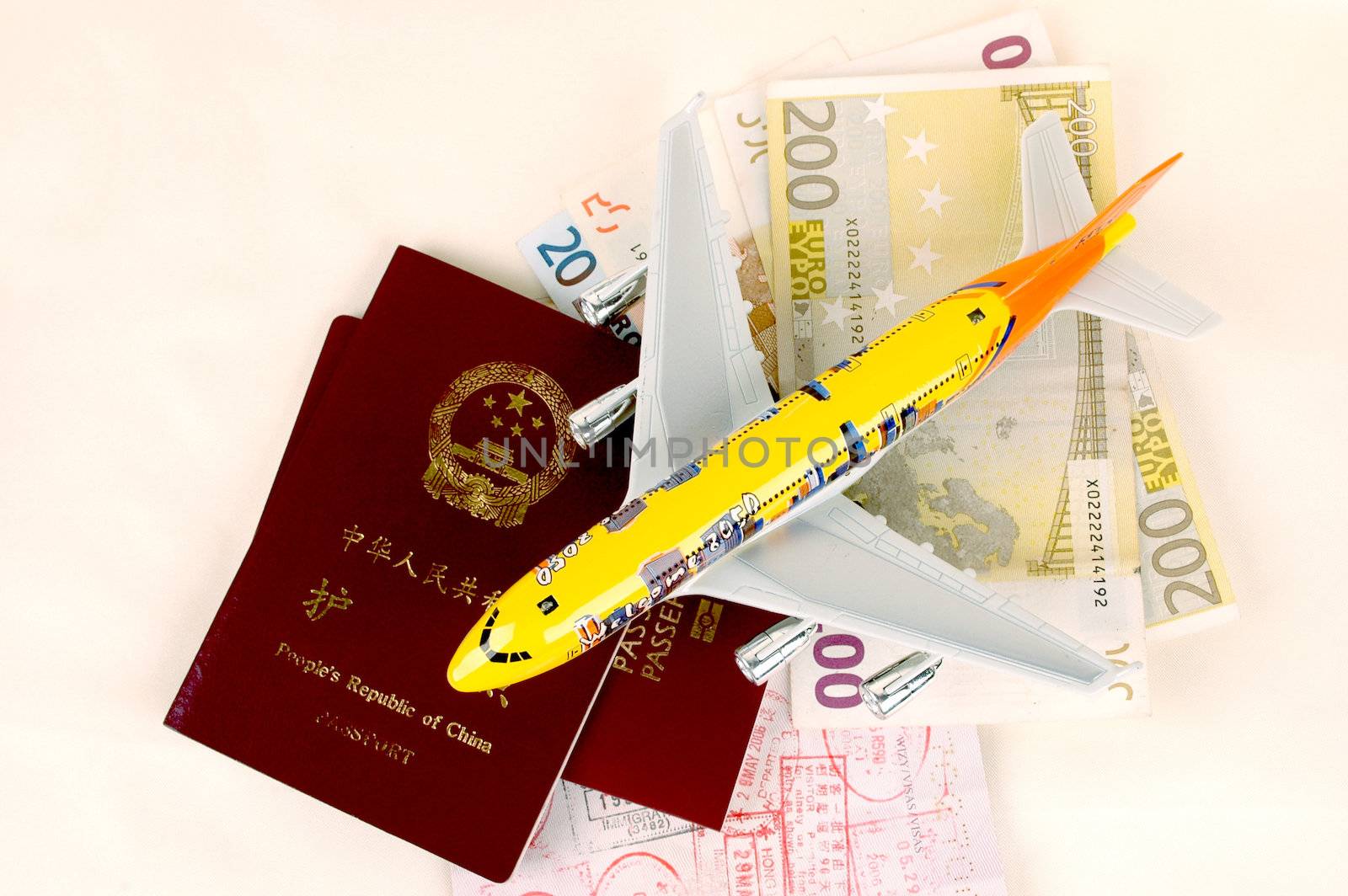 Passports from Europe and China, stamps from borders, Euro money and small plane.