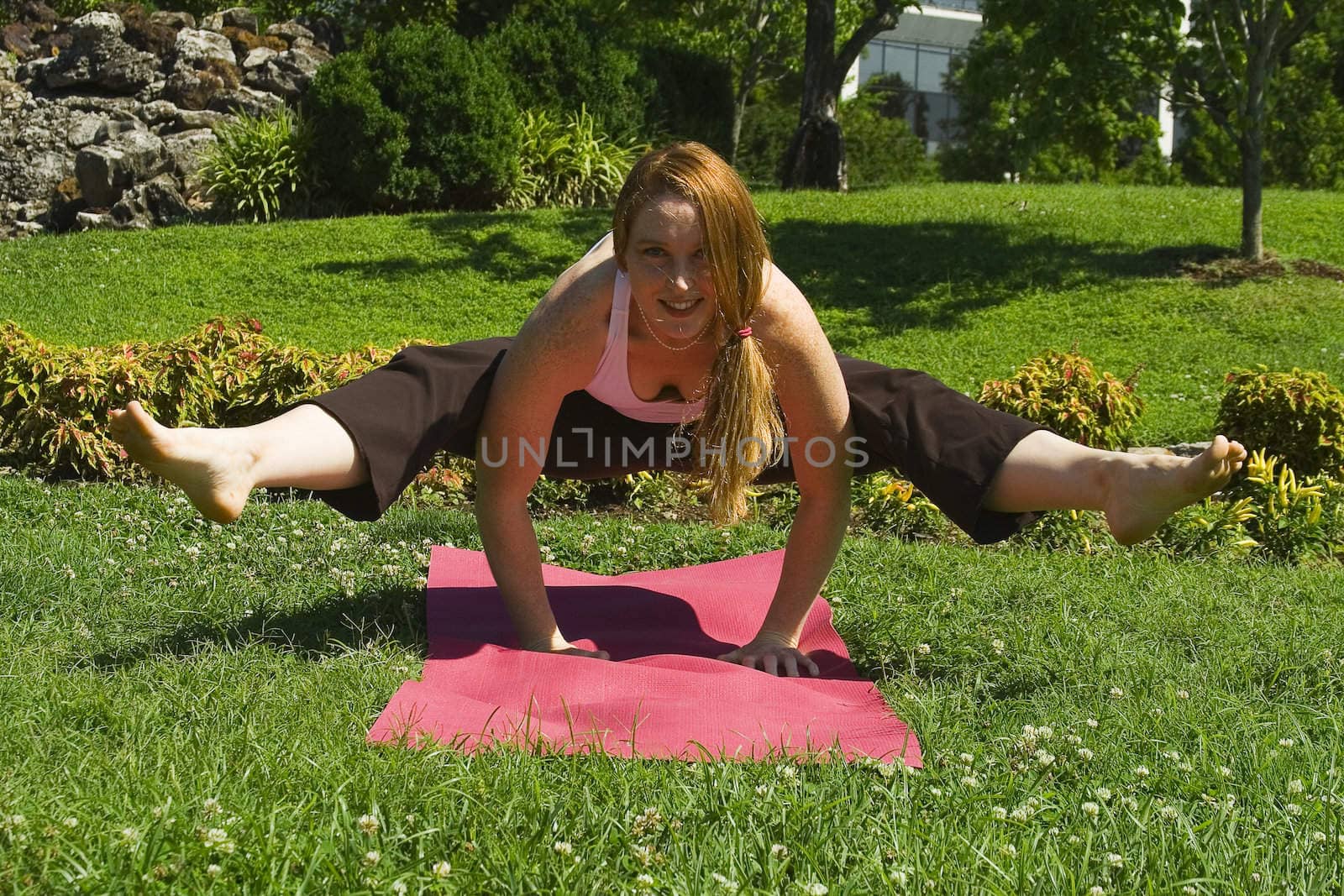 Model carries out a series of yoga positions in the park.