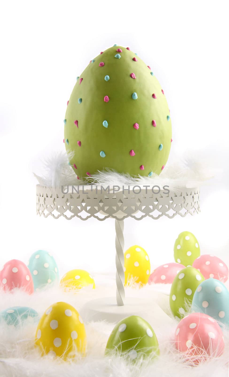 Large colored easter egg with feathers on dessert stand
