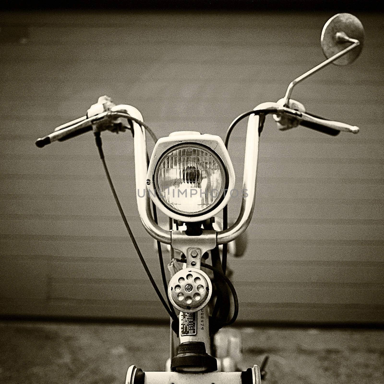Classic 70's scooter, in front of garage door.