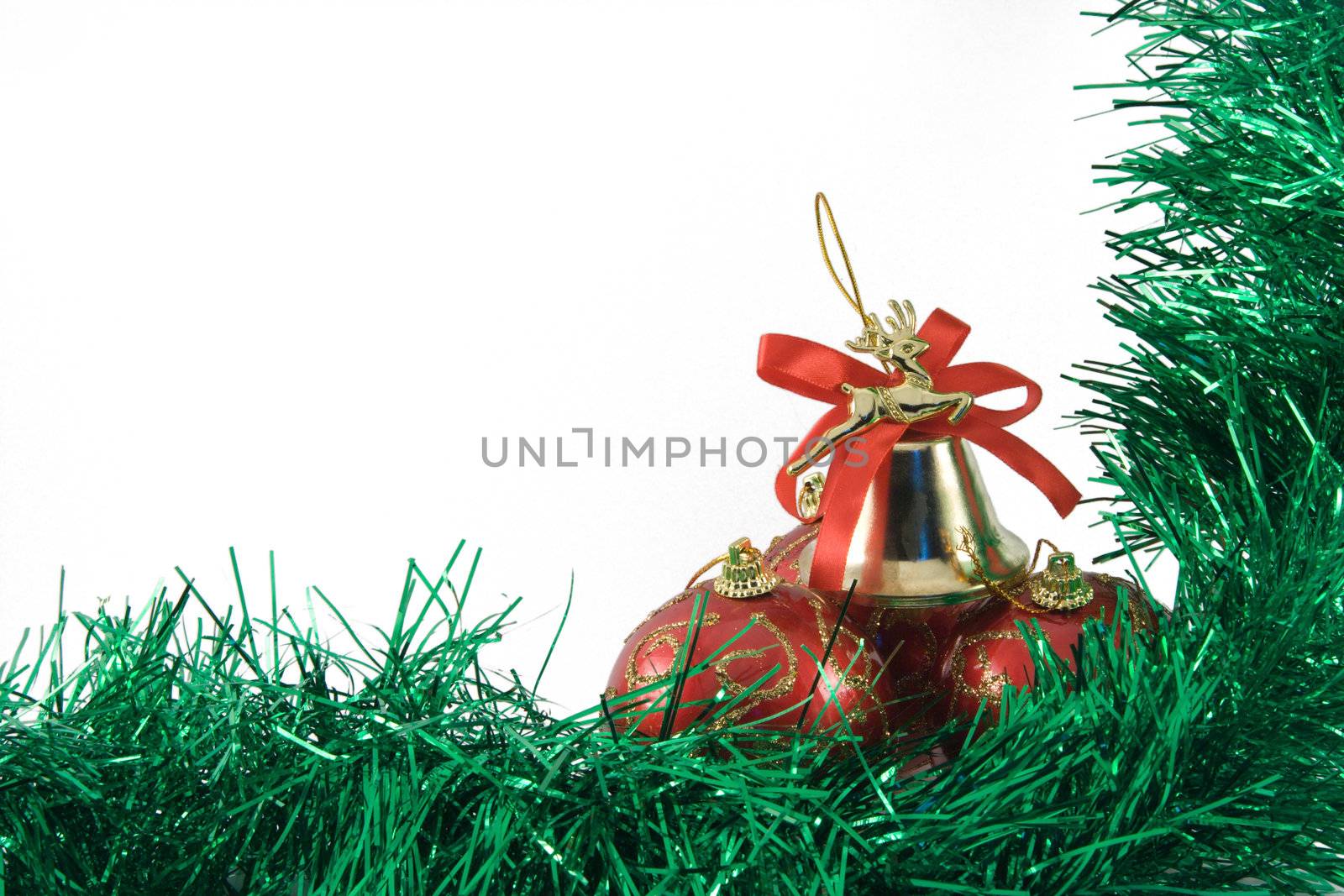 Three spheres and handbell in a tinsel on a white background