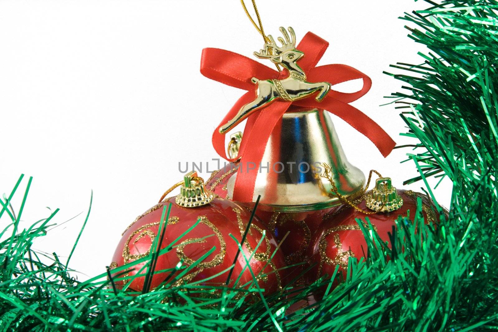 Three spheres and handbell in a tinsel on a white background