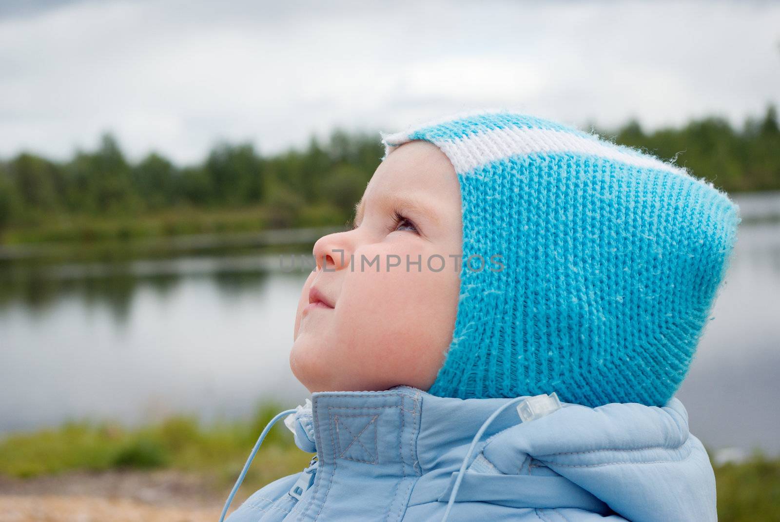 The boy looks upward.Young boy  on the nature