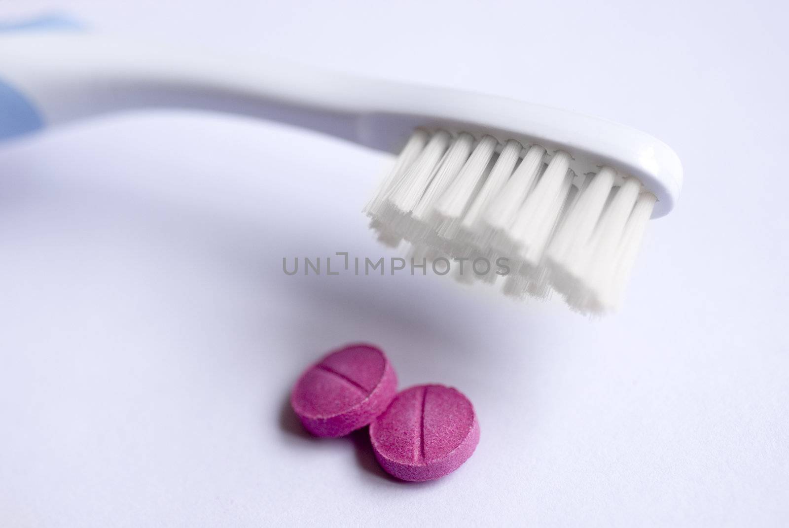 tooth brush and two dental disclosing tablets