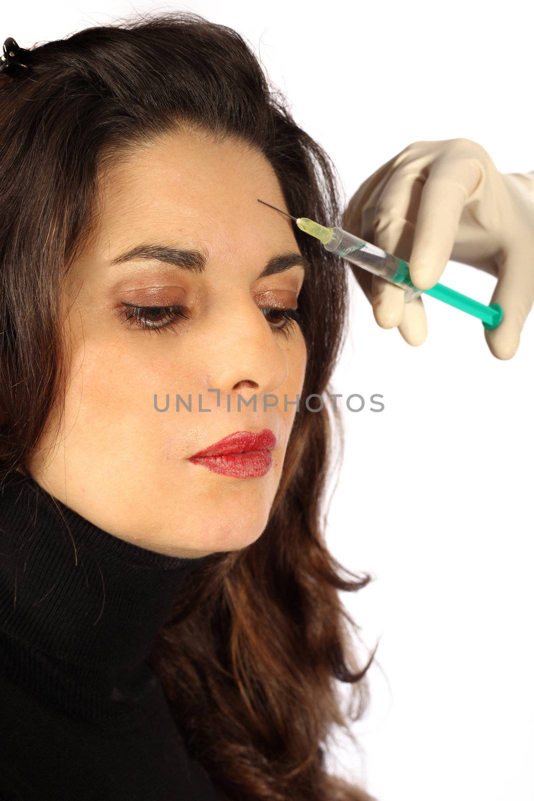 Young woman receives botox injection in her forehead - Close-up