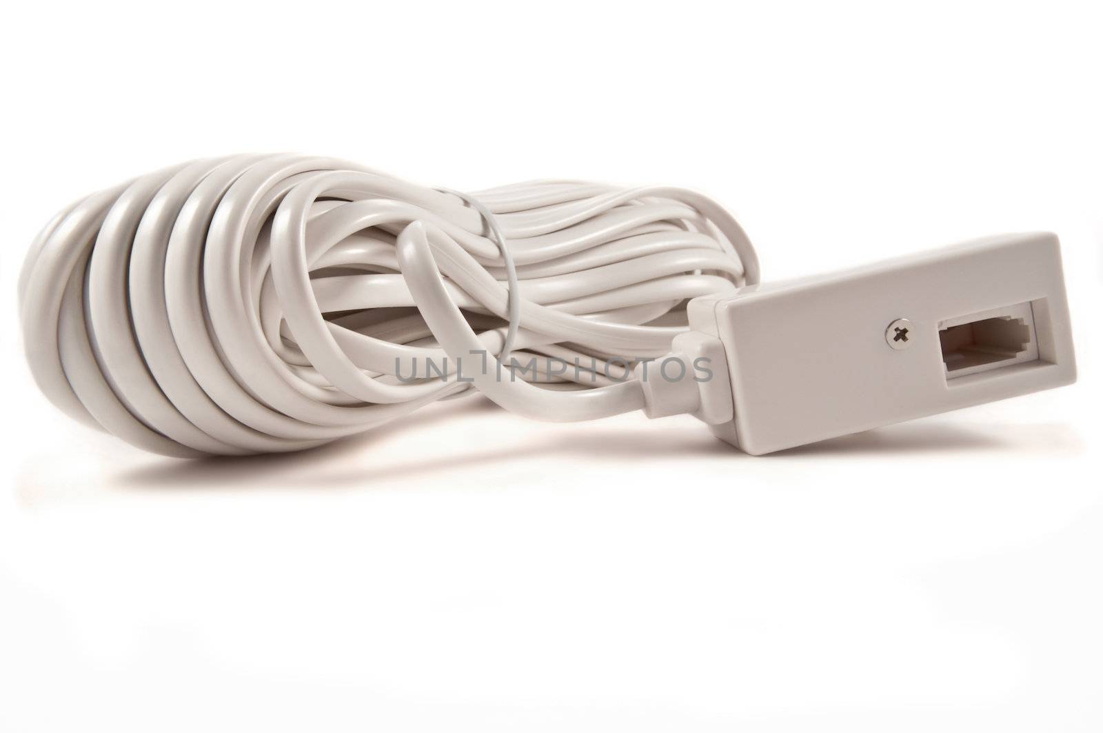 Close and low level angle of a white telephone extension cable arranged over white.