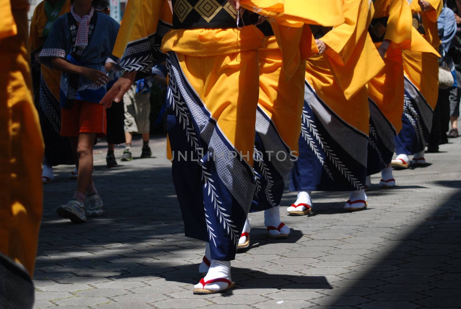 Line of Japanese ladies in Summer kimonos walk towards the camera