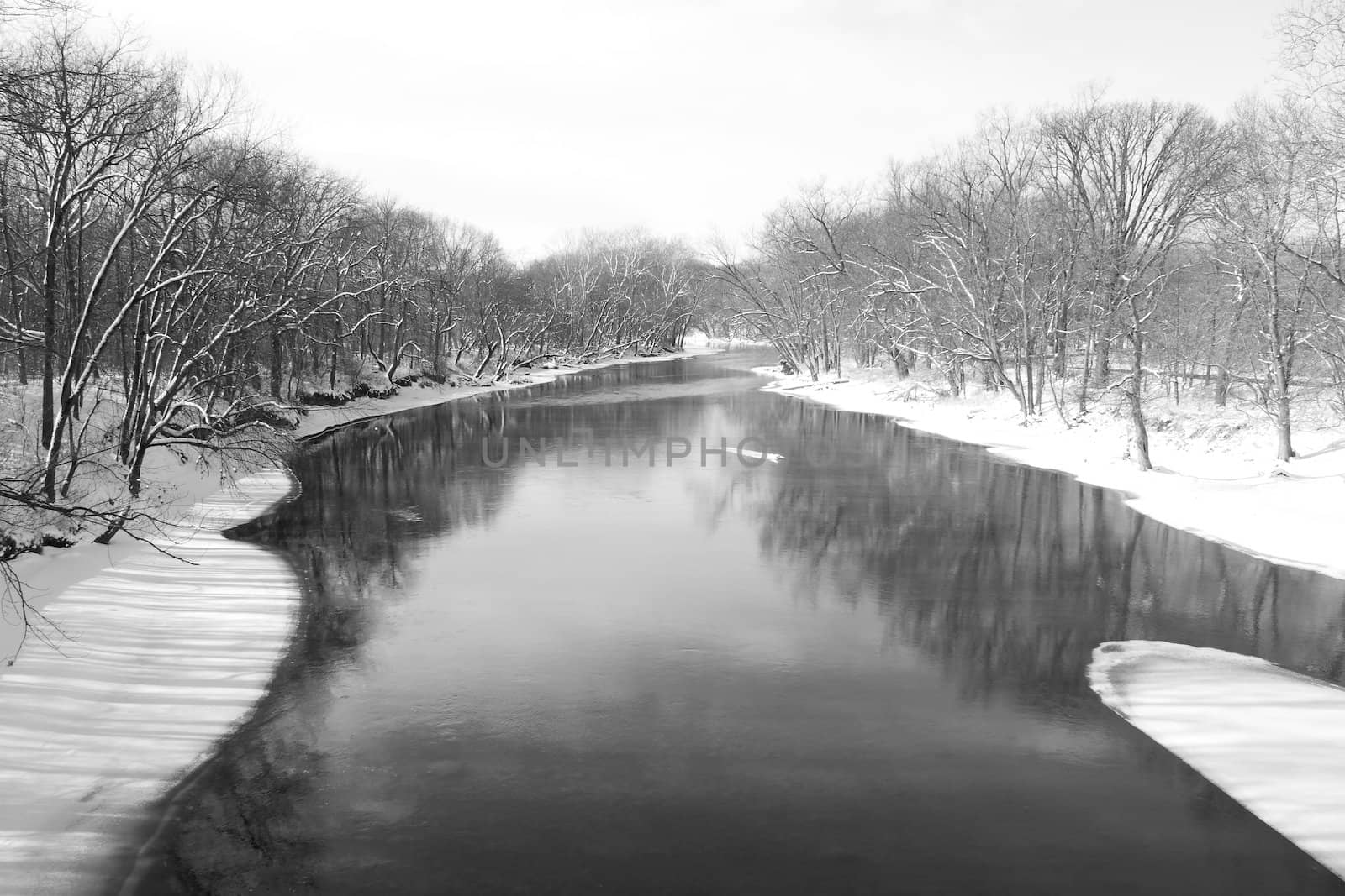 An icy river lowing through a winter landscape.
