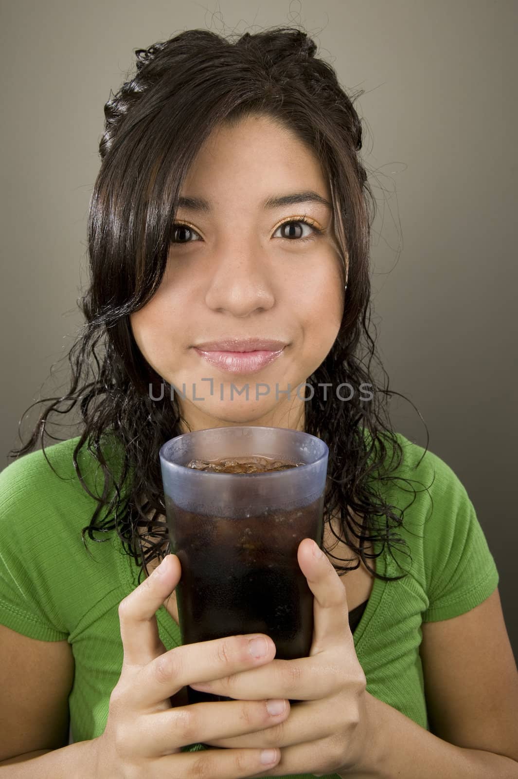 Portrait of a Latina with a cup of iced soda.