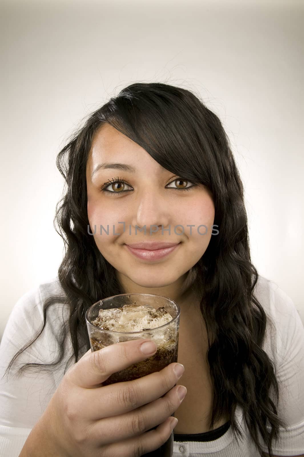 Portrait of a latina teenager with a cup of soda and ice.