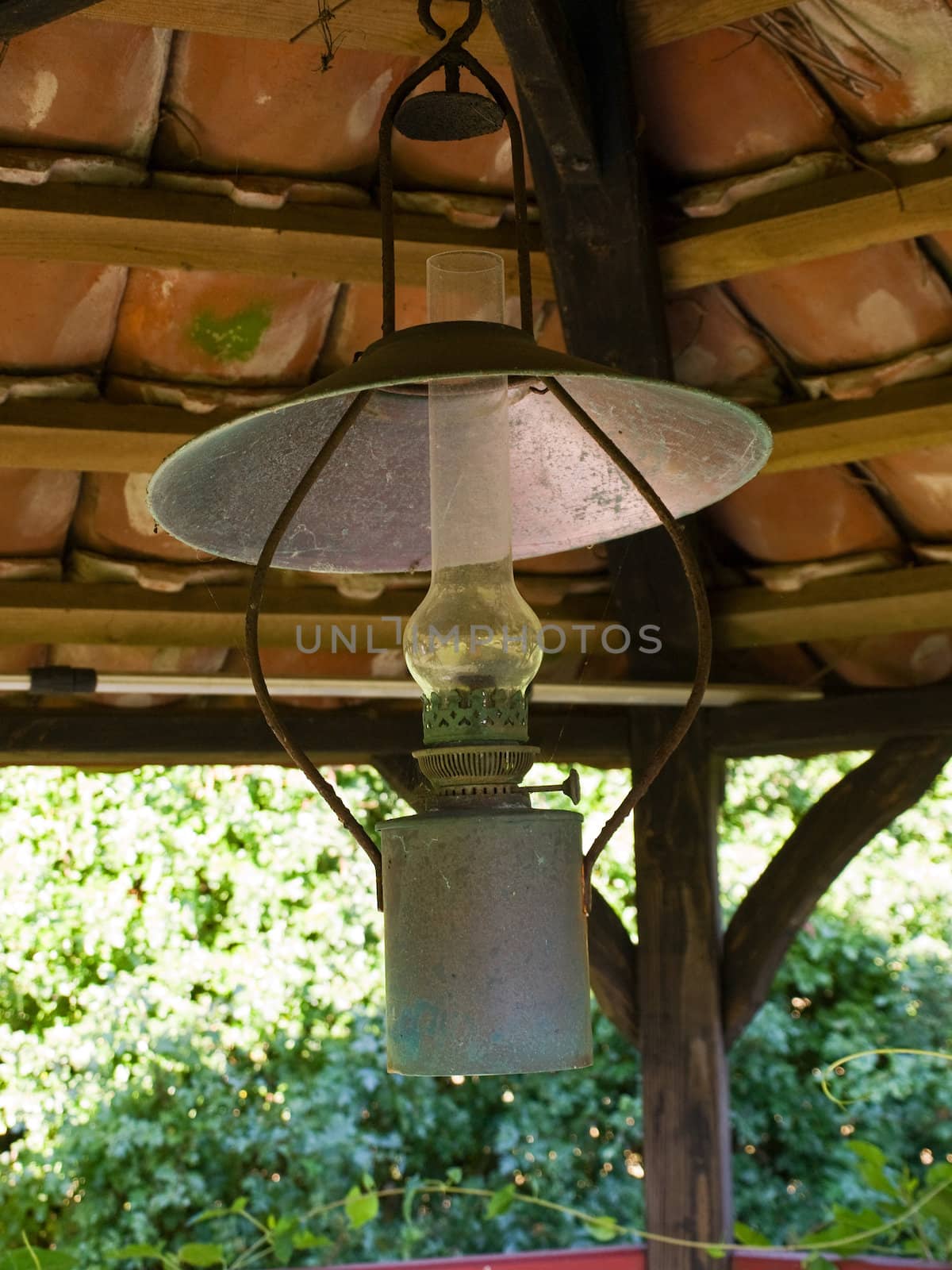 Old beautiful decorative copper oil lamp in a garden gazebo