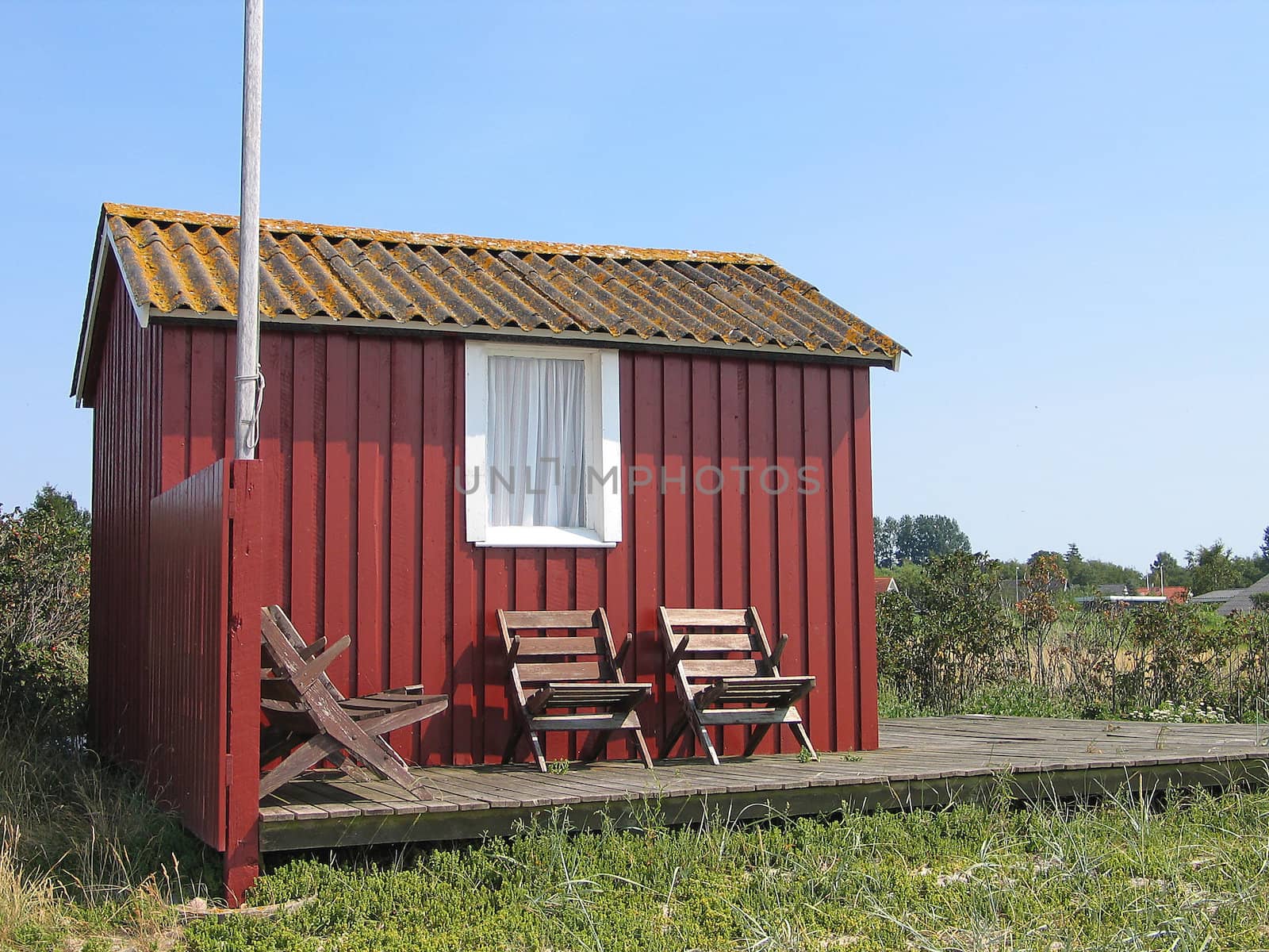 Cute little red summerhouse by the sea
