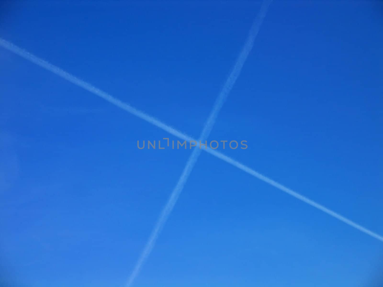 Aerial crossroad clear blue sky with crossing jets contrails