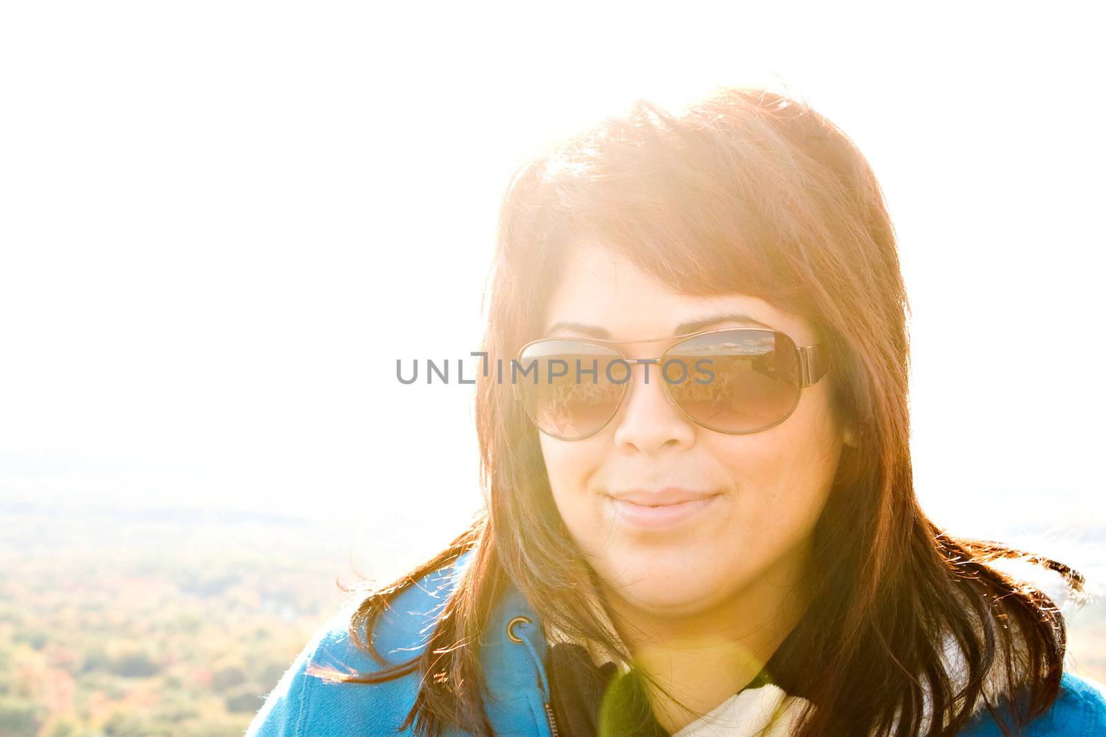 Portrait of an attractive brunette woman with intentional lens or sun flare.