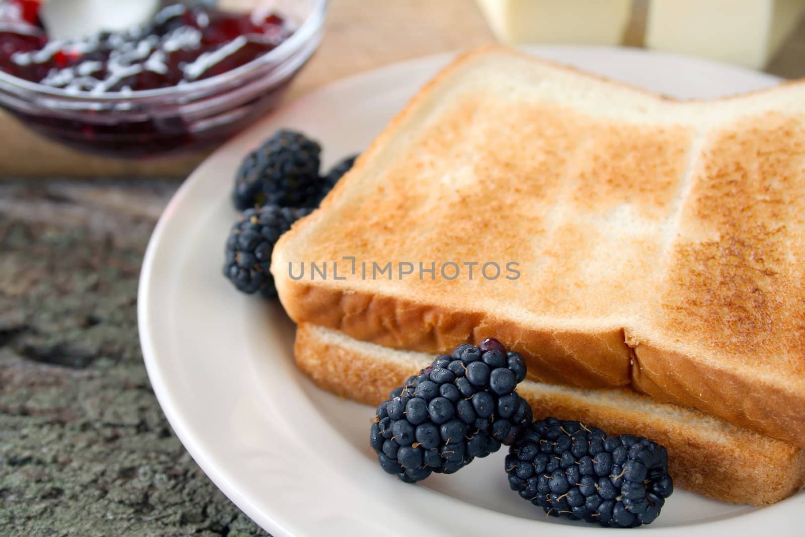 Fresh blackberries and blackberry jam with toast and butter. Used a shallow DOF on the berries and edge of toast.
