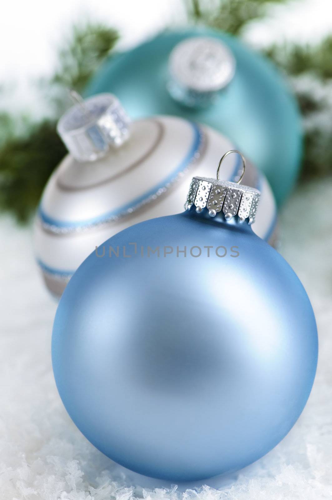 Closeup of three Christmas decorations sitting in snow