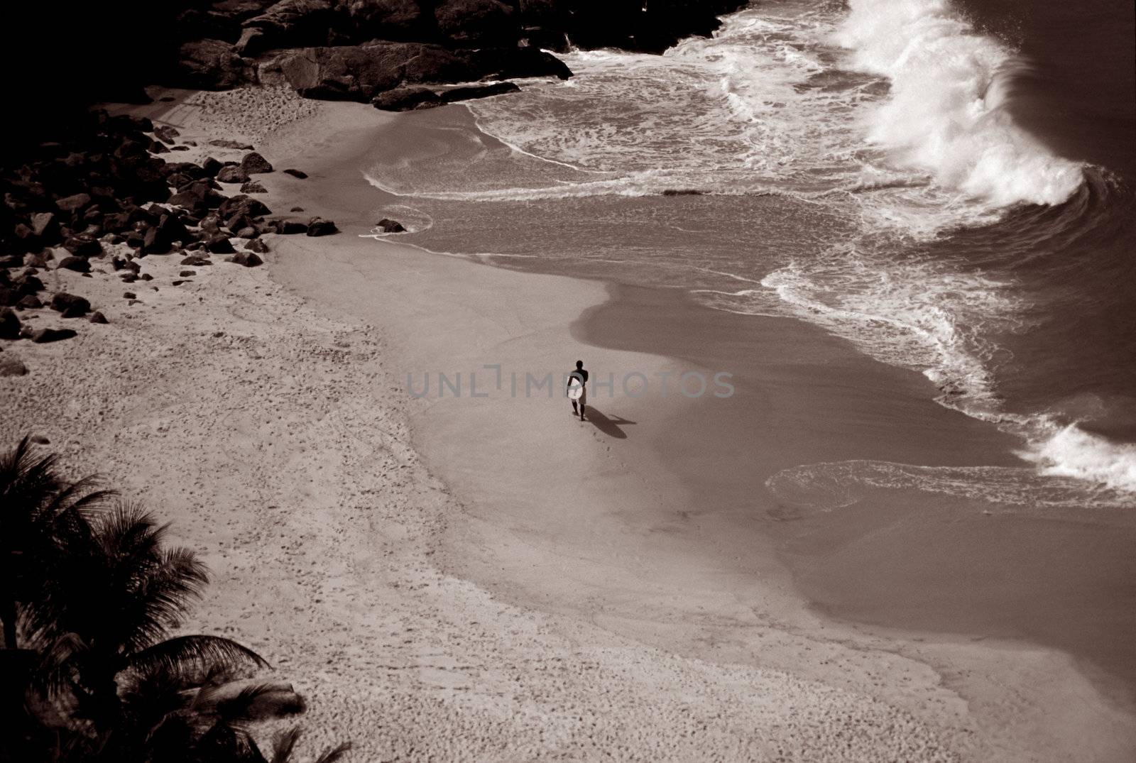 Black and White of a lone surfer on beach Rio De Janeiro Brazil