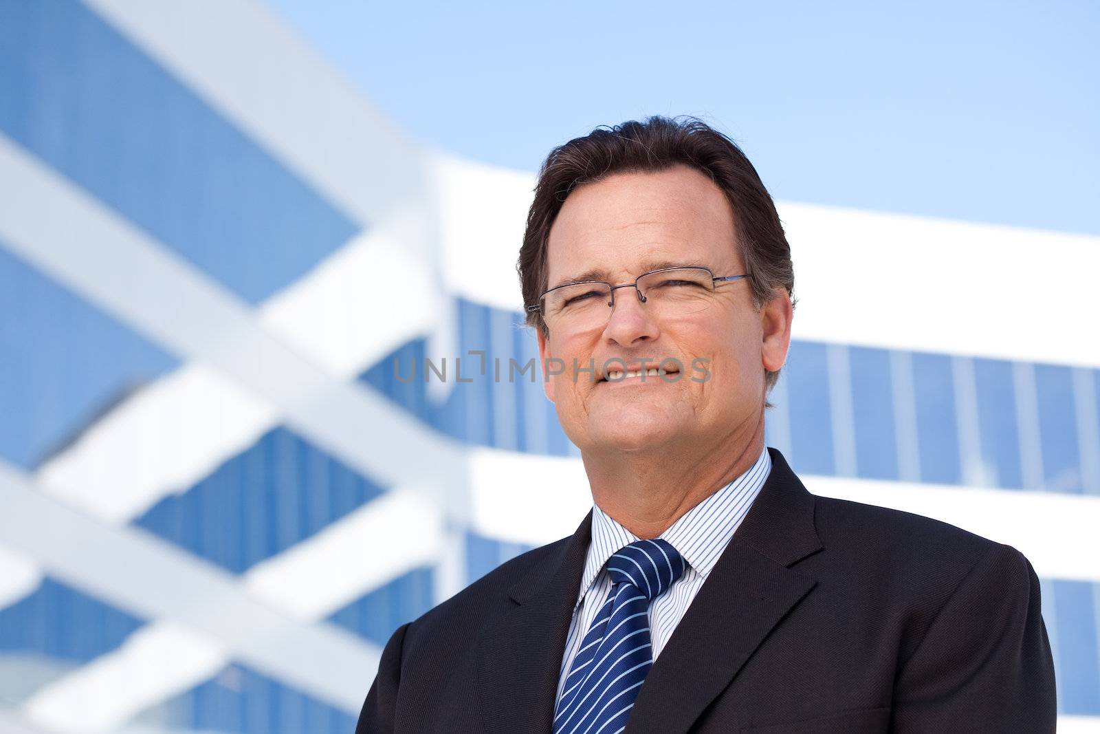 Handsome Businessman Smiling in Suit and Tie Outside of Corporate Building.