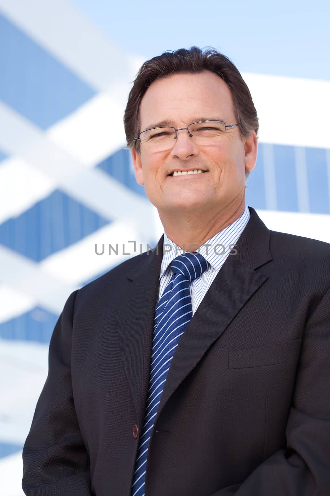 Handsome Businessman Smiling in Suit and Tie Outside of Corporate Building.