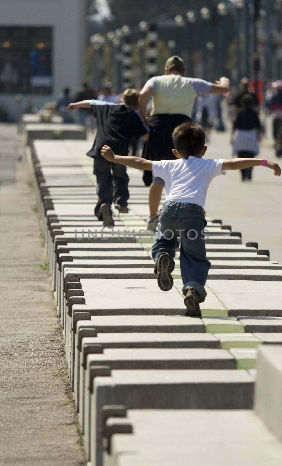 Kids playing and jumping across cement
