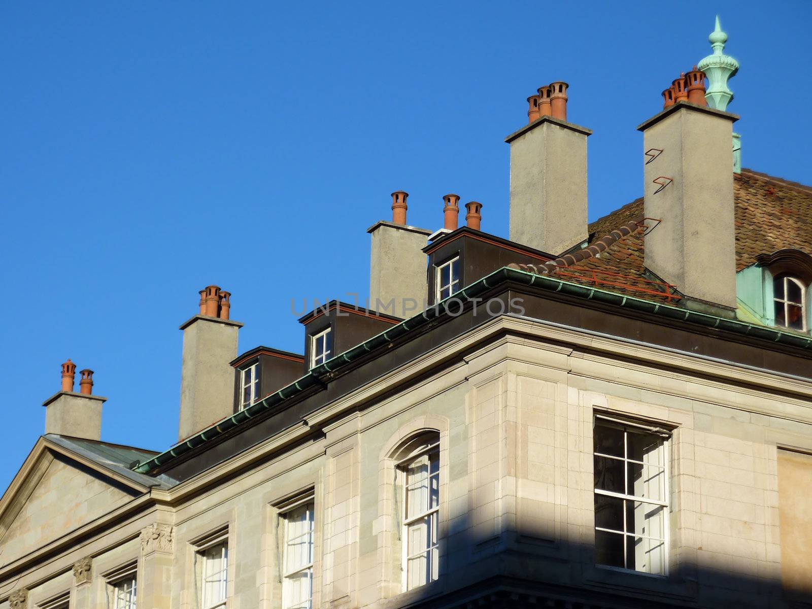 Many chimneys on the roof of an old building by beautiful day