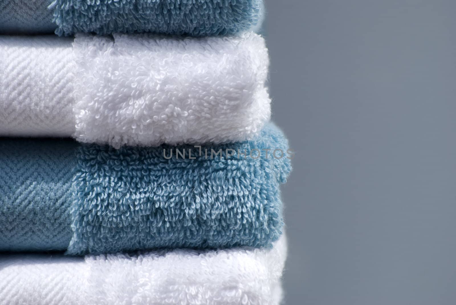 Blue and white cotton towels on plain background