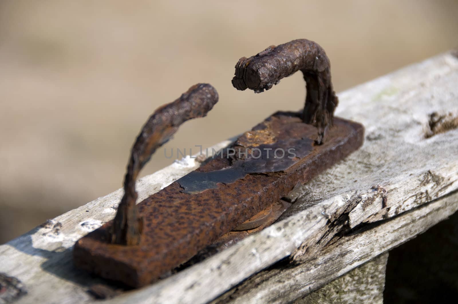 An old rusty handle on a wooden boat