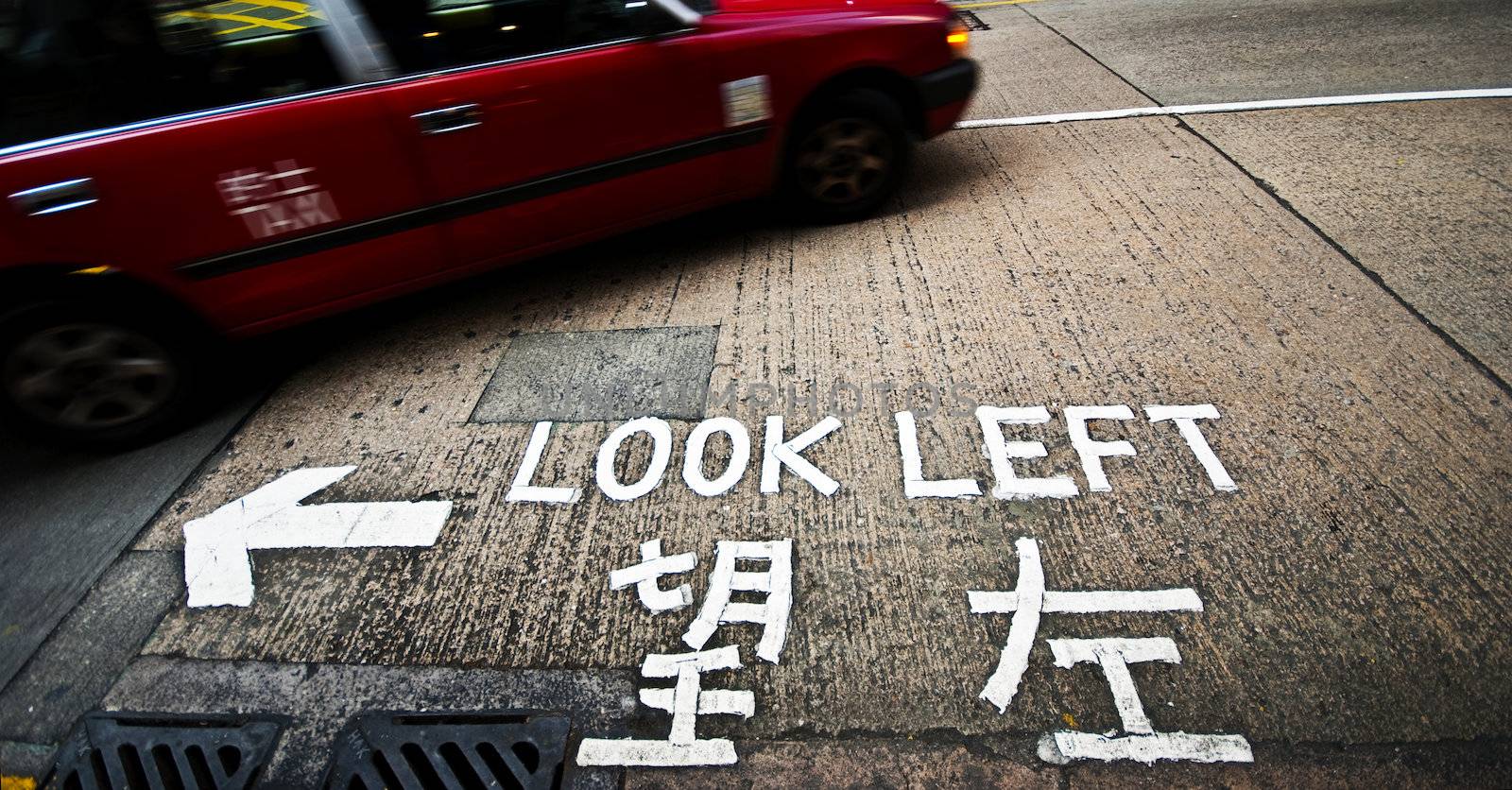 A sign at a street crossing in Hong Kong reminding tourists to look left before crossing
