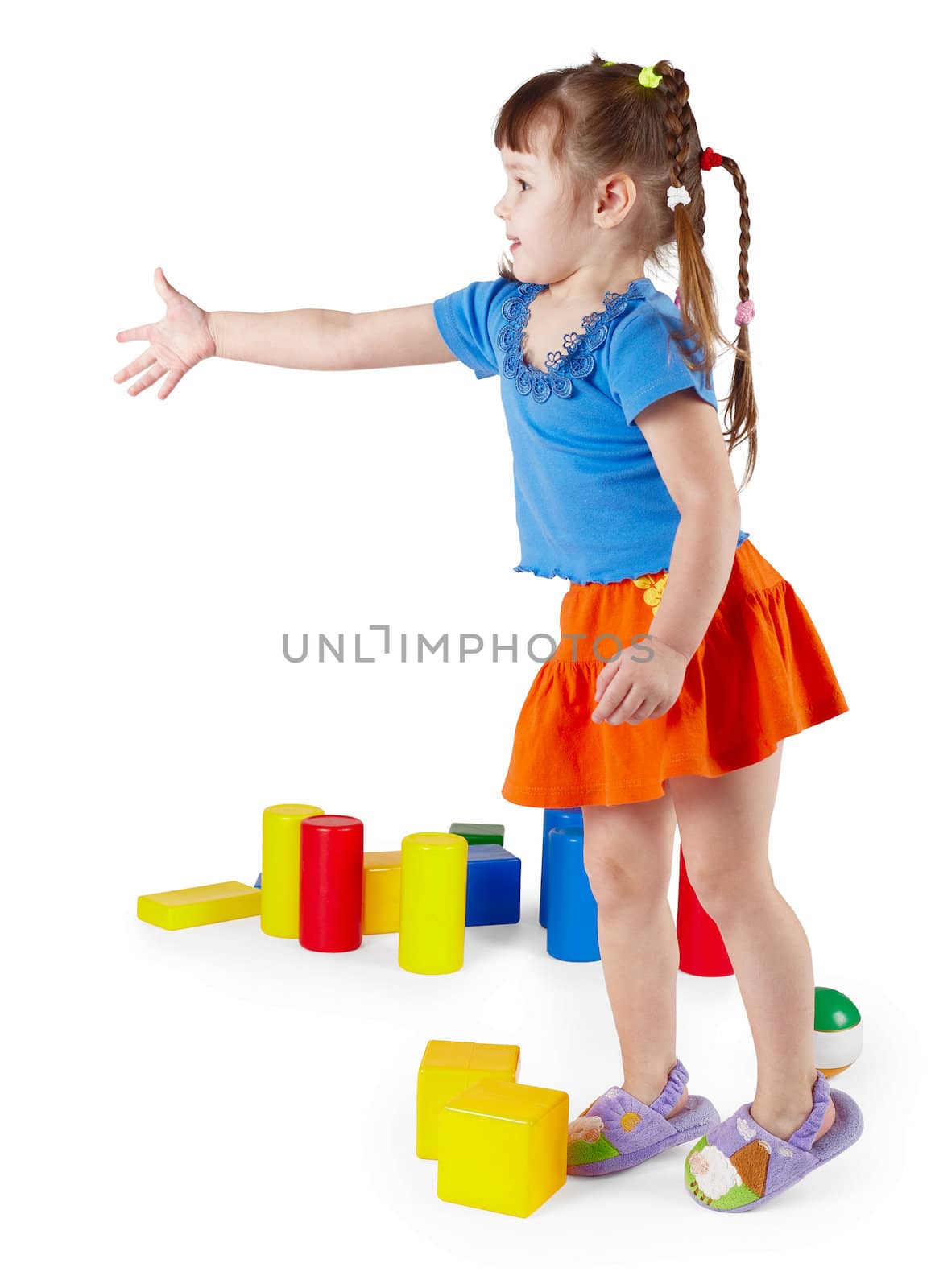 The little girl in a dress with toys on a white background