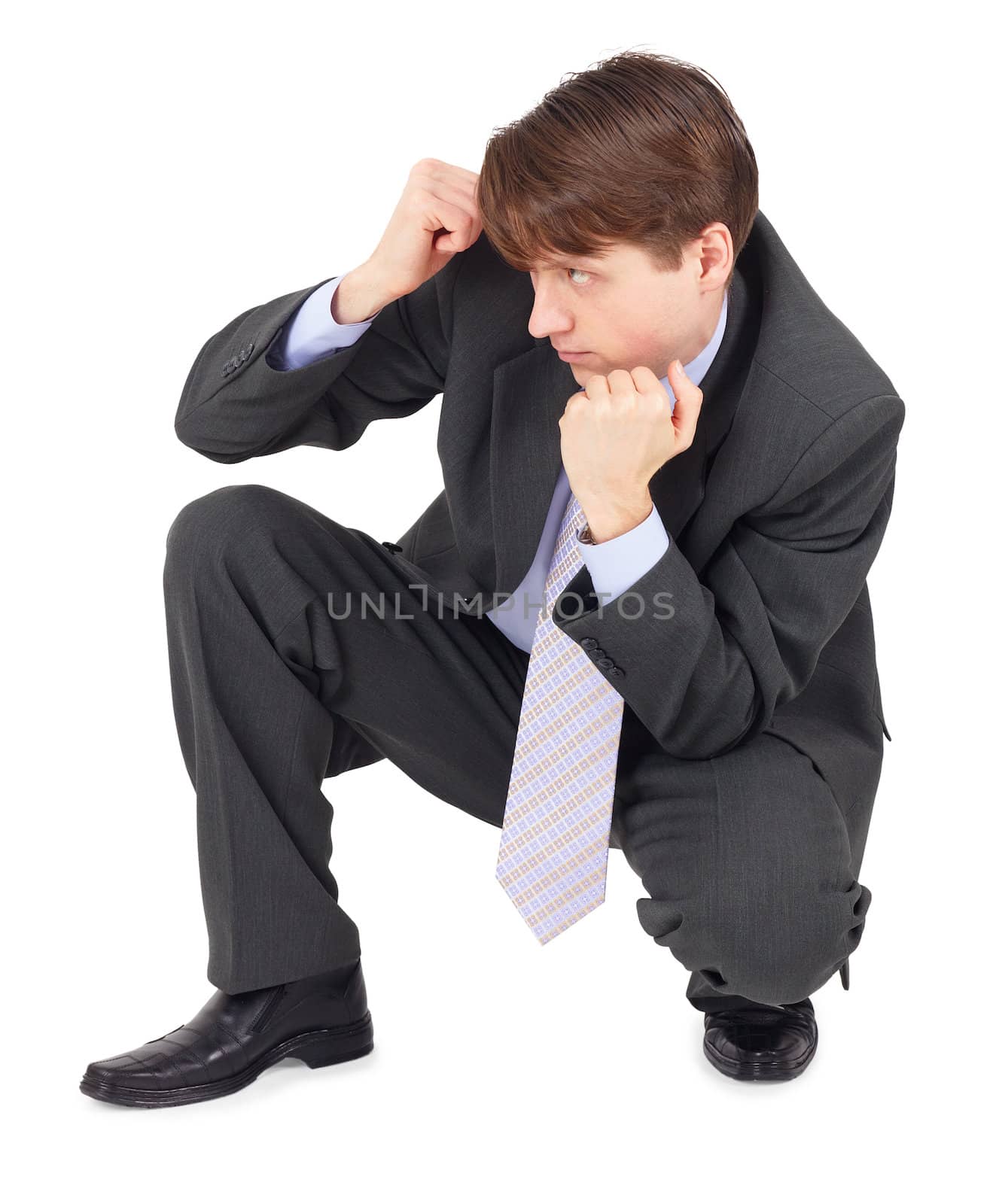 A young man sits in a defensive pose, isolated on a white background