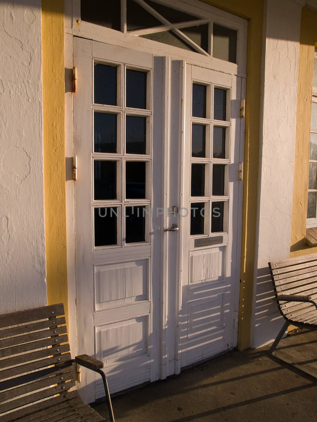 Classical traditional white wooden door with armchairs home entry