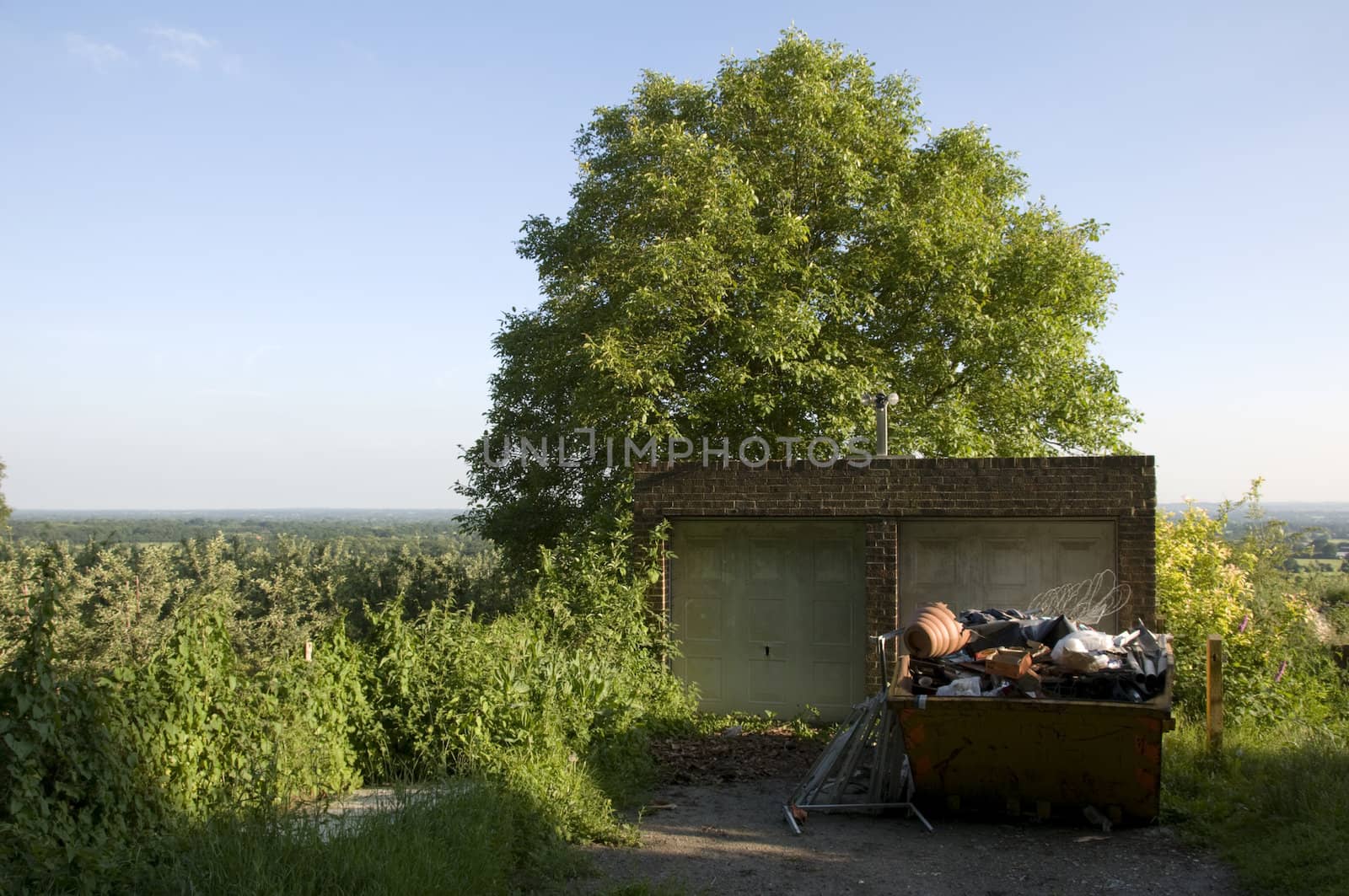 A rubbish skip in the countryside with clear blue sky