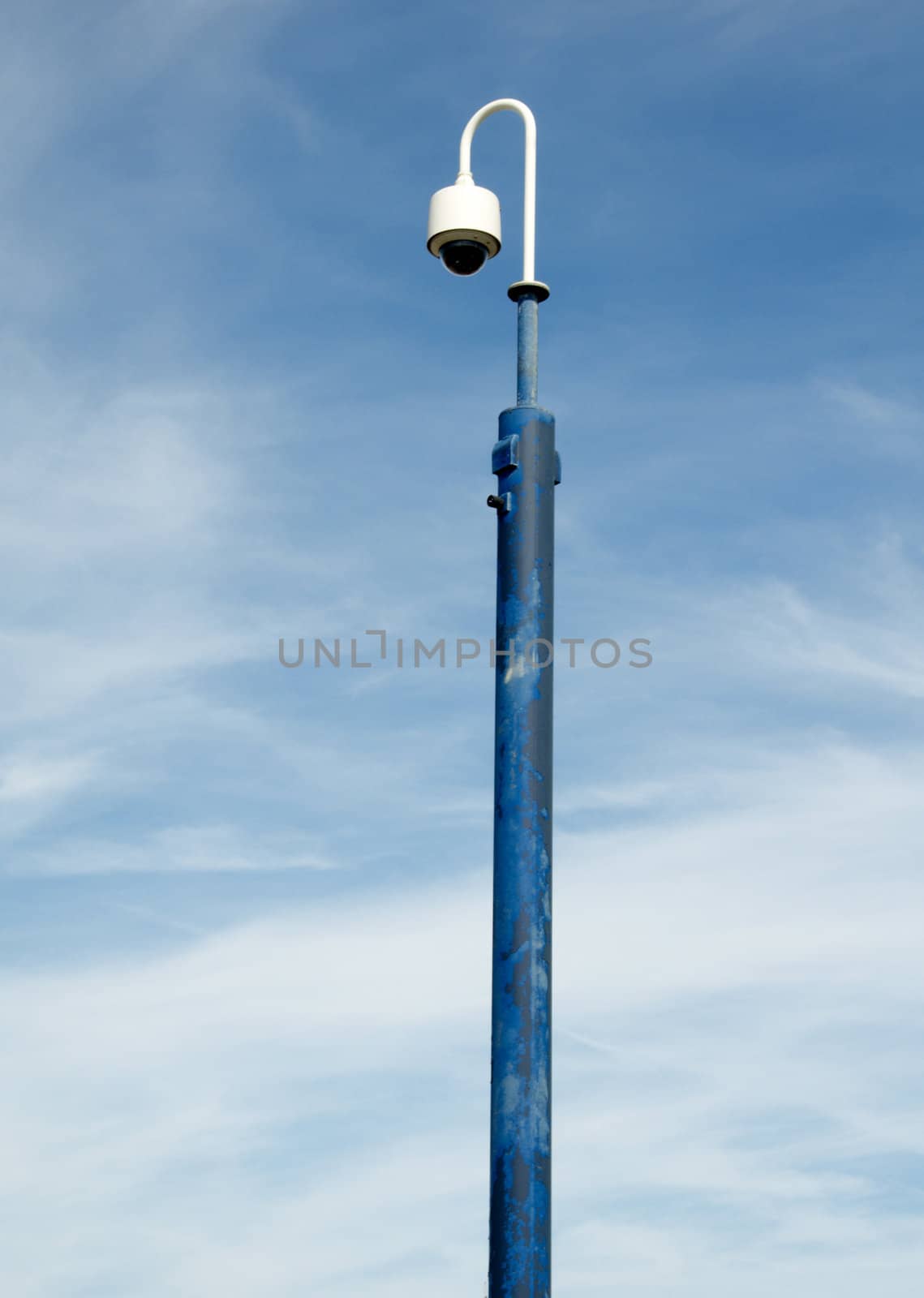 A lamp post with a blue sky in the background