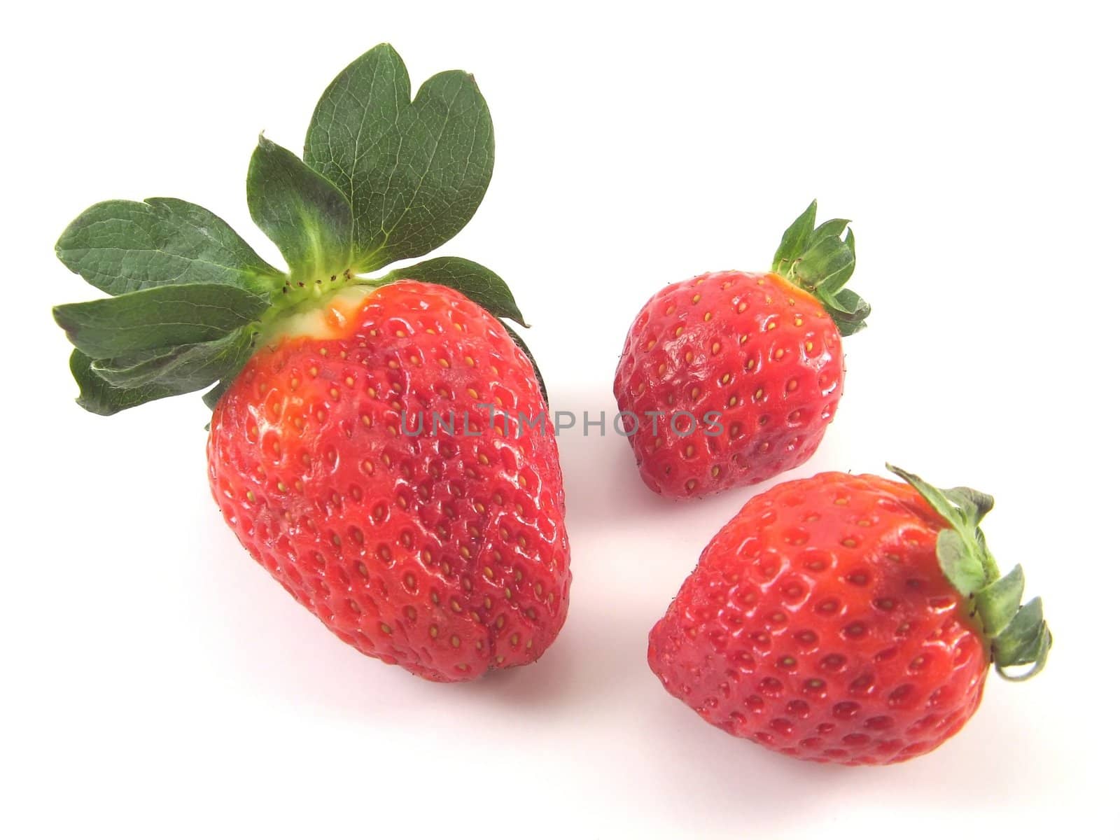 three fresh strawberries over a white background
