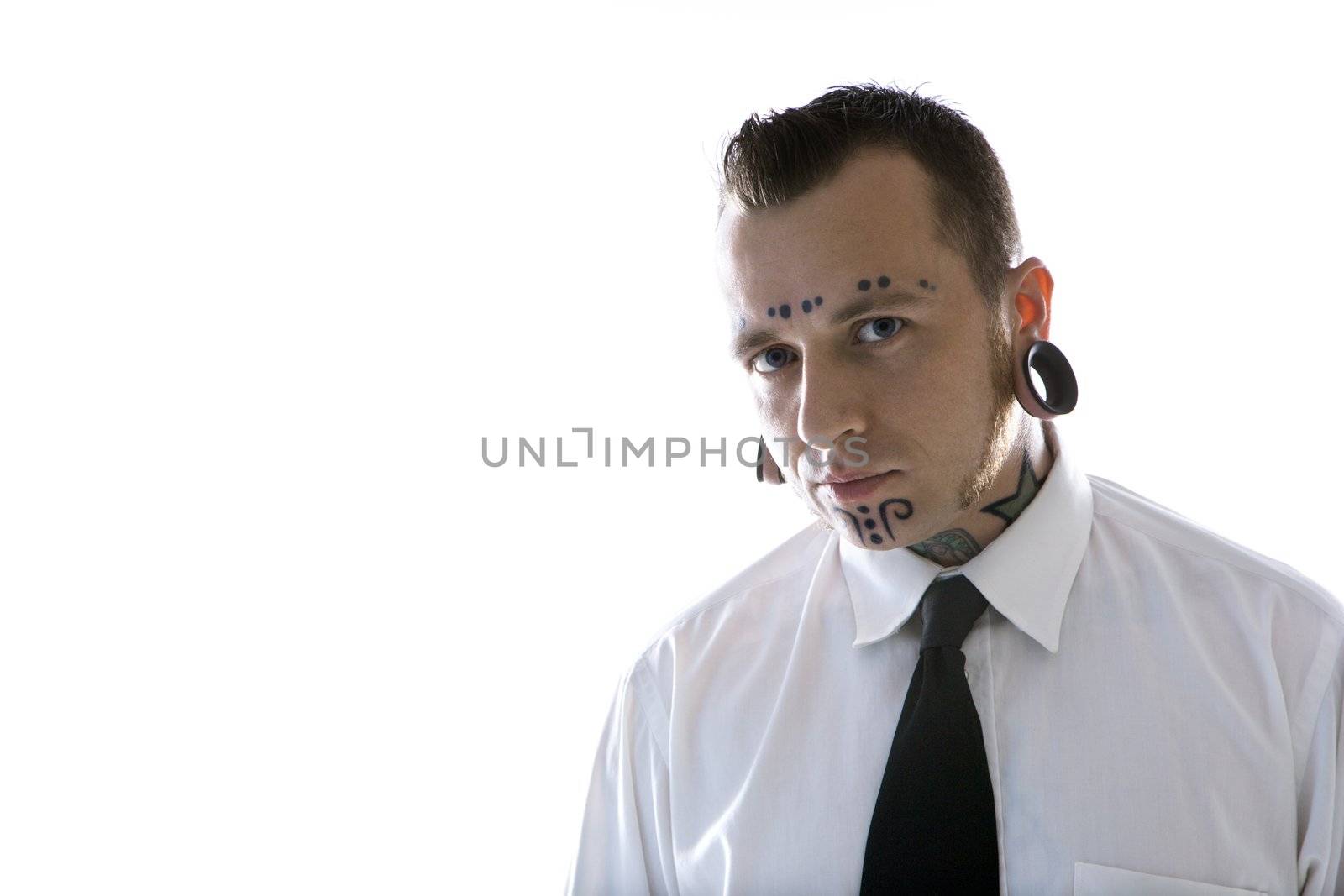 Caucasian mid-adult man with tattoos and piercings wearing necktie.