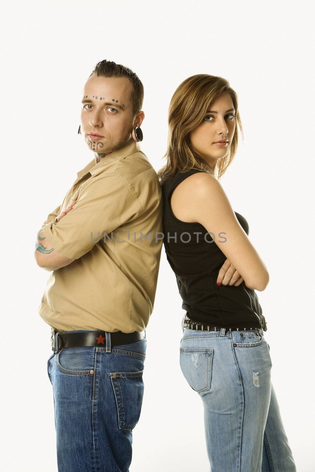 Caucasian mid-adult man and teen female standing back to back.