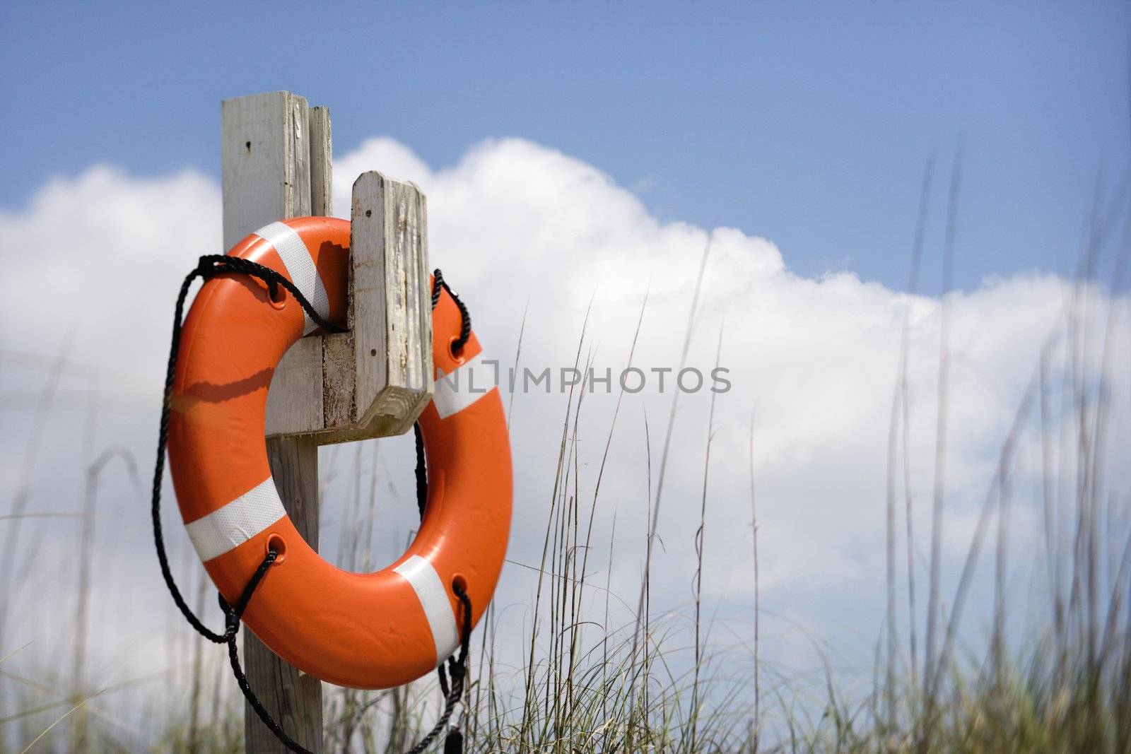 Life preserver hanging on post on beach on Bald Head Island, North Carolina.