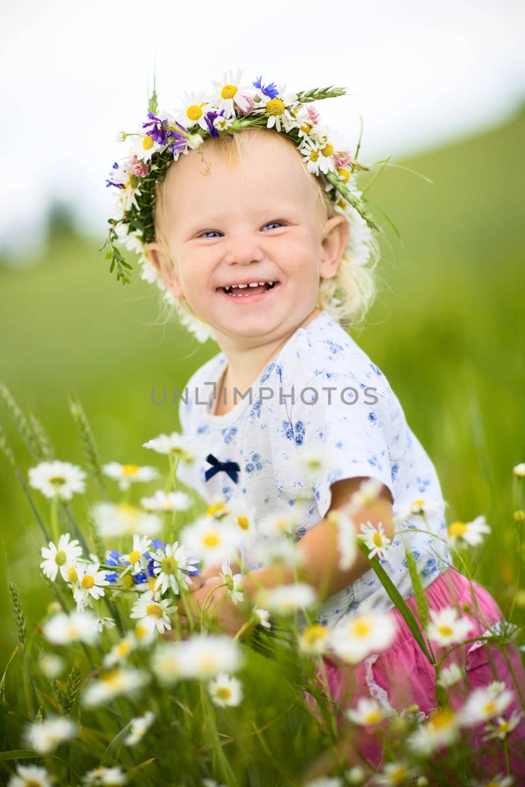 happy small girl with field flowers