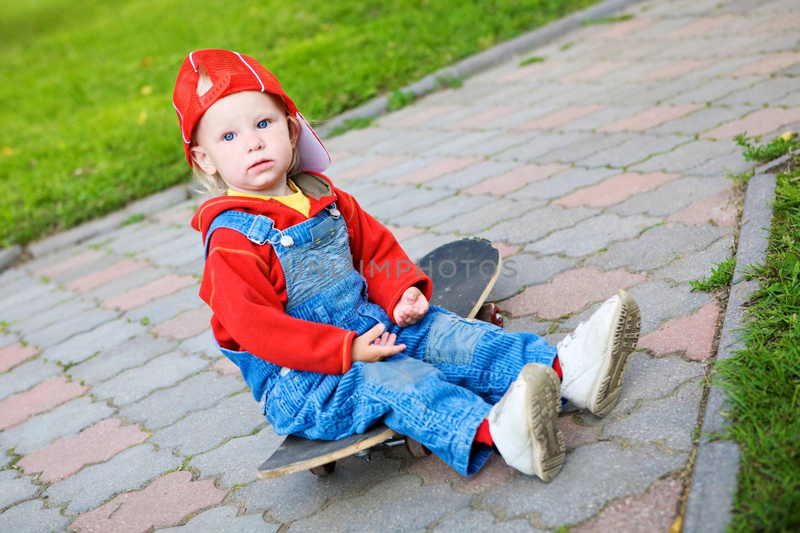 child of 2 years old sitting on the skateboard