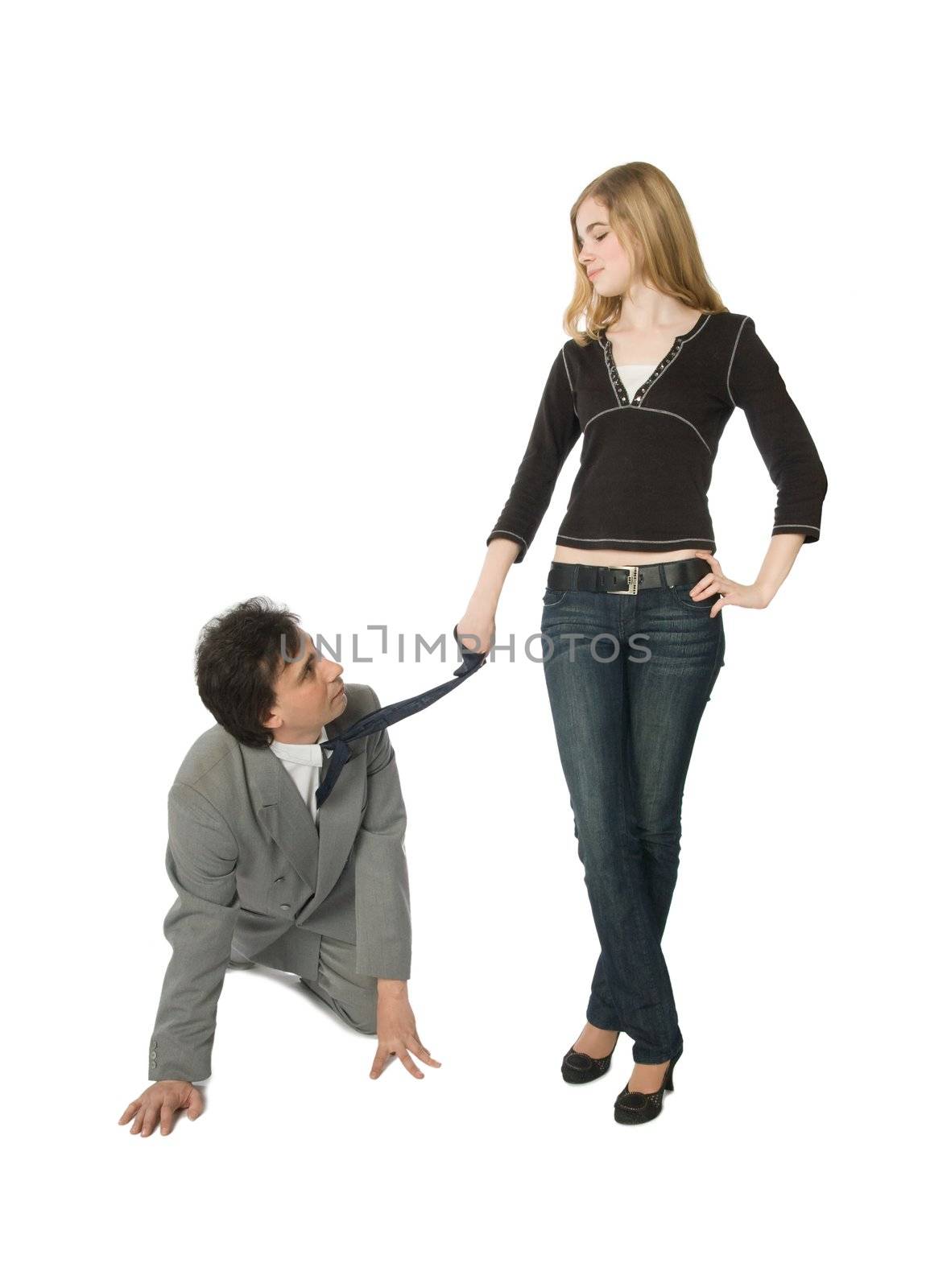 A man on all fours and a young woman pulling him by a necktie