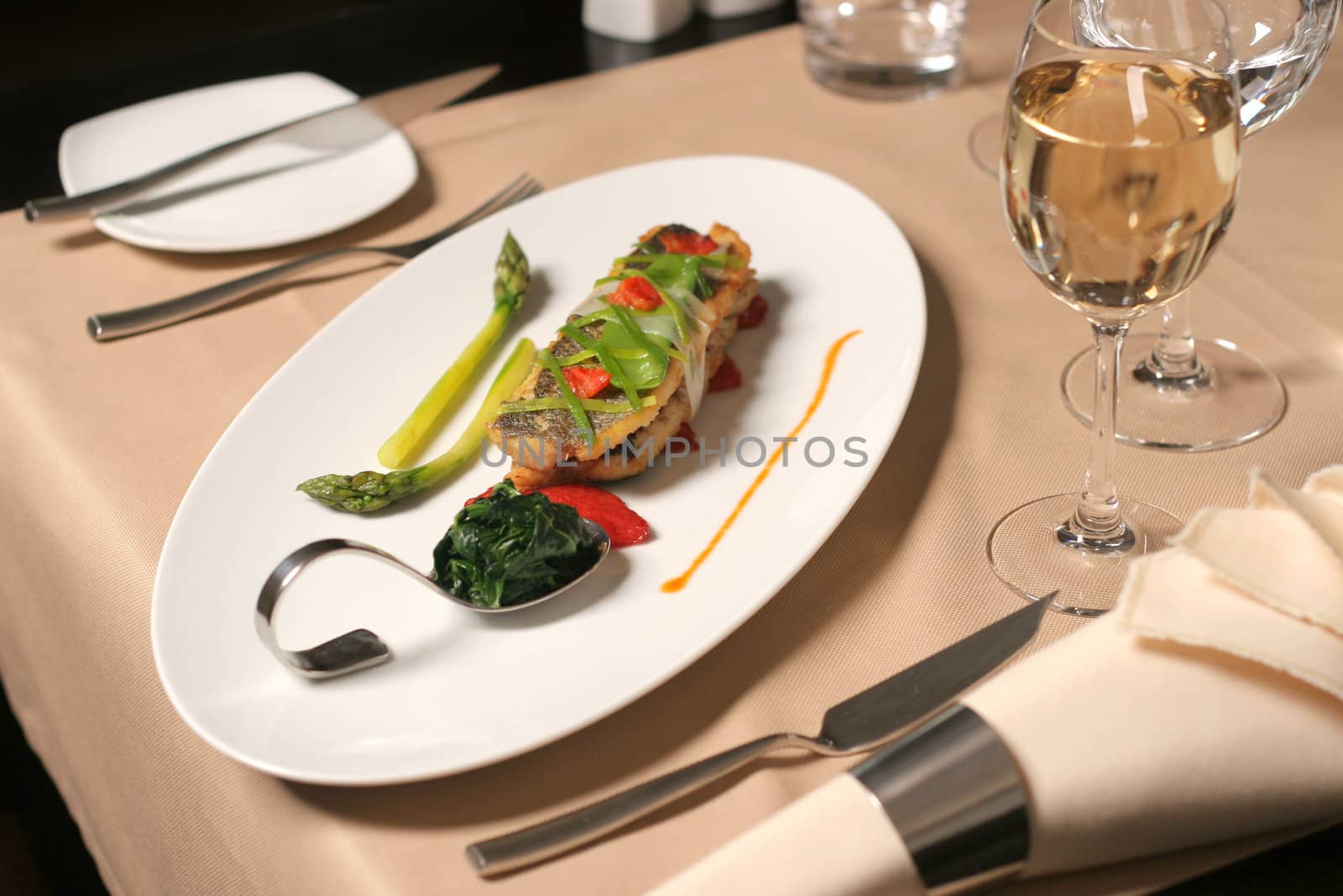 restaurant table with fish asparagus and spinach plate