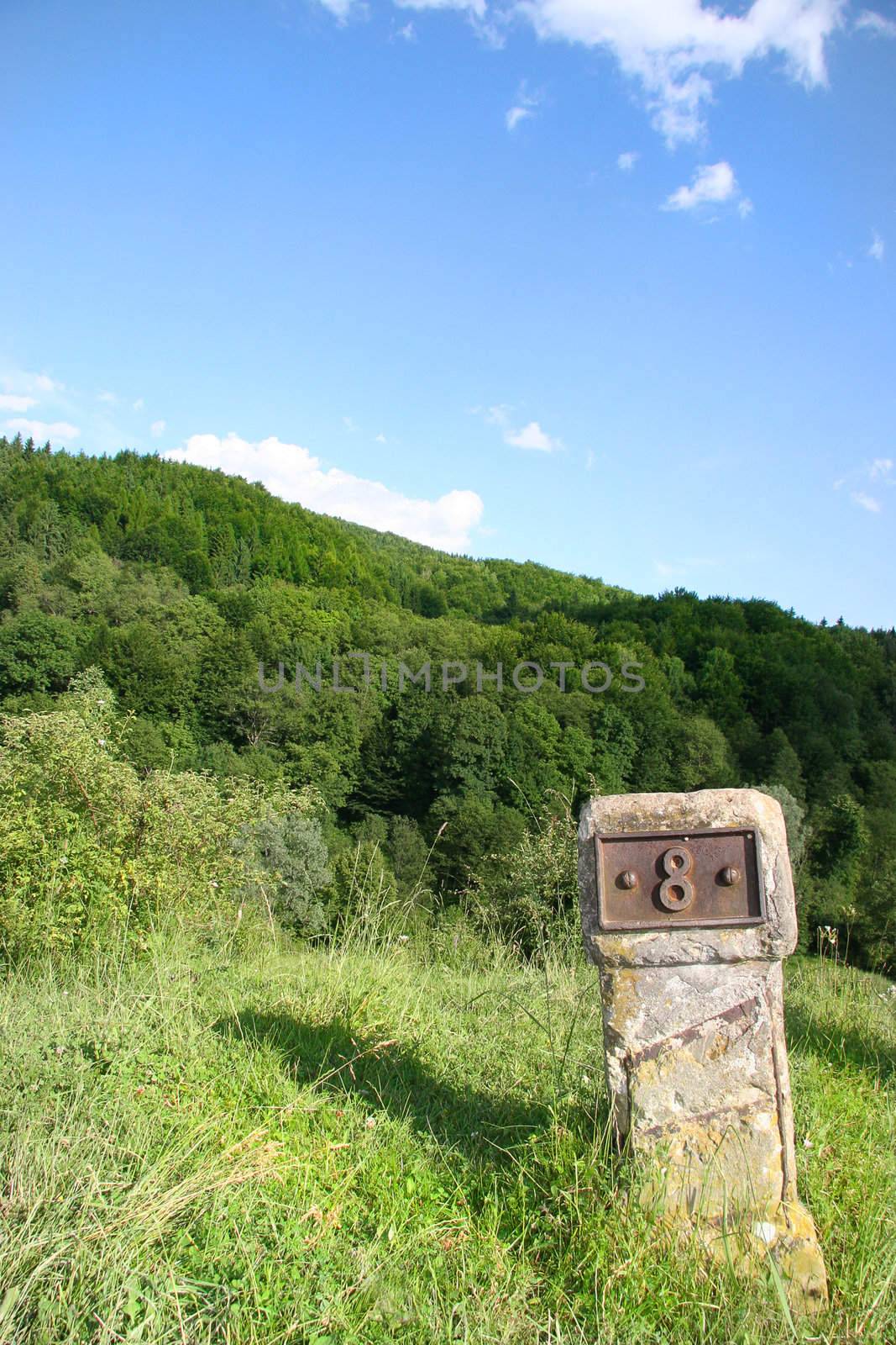 milestone marked with eight and positioneda on a hill
