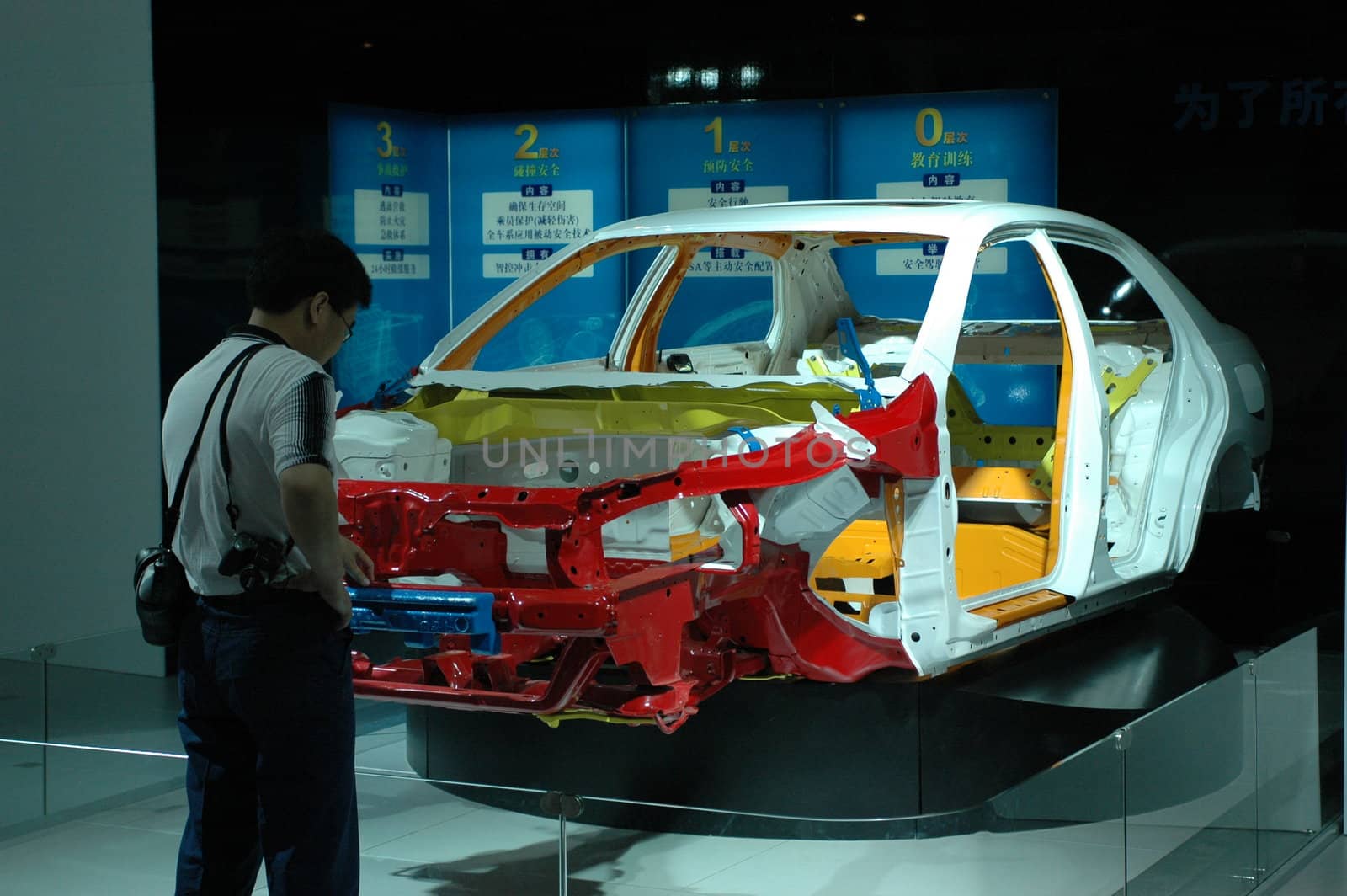 China, Shenzhen Moto - car show in exhibition center. Visitors watching European, American and Chinese cars. Person interested in newest moto technology.